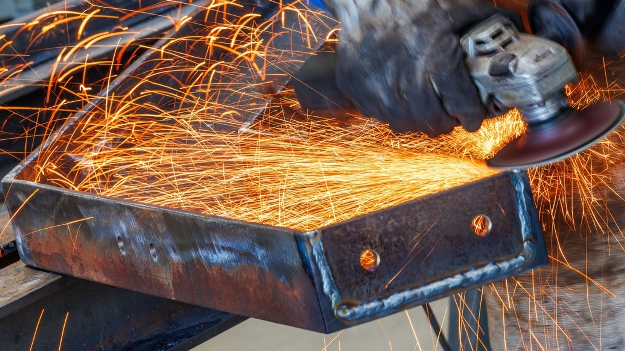Ein Metallbauer schleift ein Stahlteil für eine Metallkonstruktion. | Bild: dpa-Bildfunk/Jens Büttner Ein Metallbauer schleift ein Stahlteil für eine Metallkonstruktion.