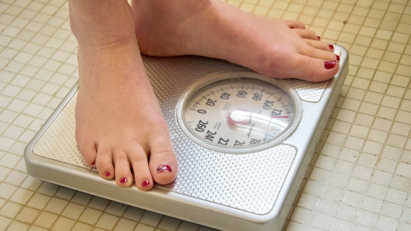 Frauenfüße auf einer Körperwaage | Bild: picture alliance / Design Pics | Joel Sartore Photography Frauenfüße auf einer Körperwaage