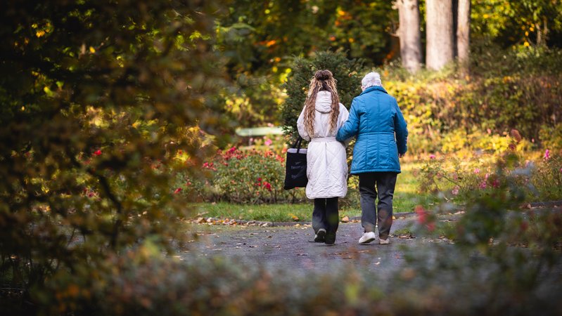 Eine junge Frau und eine Seniorin machen einen morgendlichen Spaziergang durch einen Park. | Bild: picture alliance / photothek.de | Amrei Schulz Eine junge Frau und eine Seniorin machen einen morgendlichen Spaziergang durch einen Park.