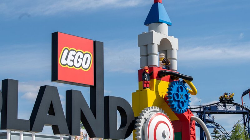 11.08.2022: Neben dem Logo am Eingang zum Legoland ist eine Achterbahn zu sehen. 