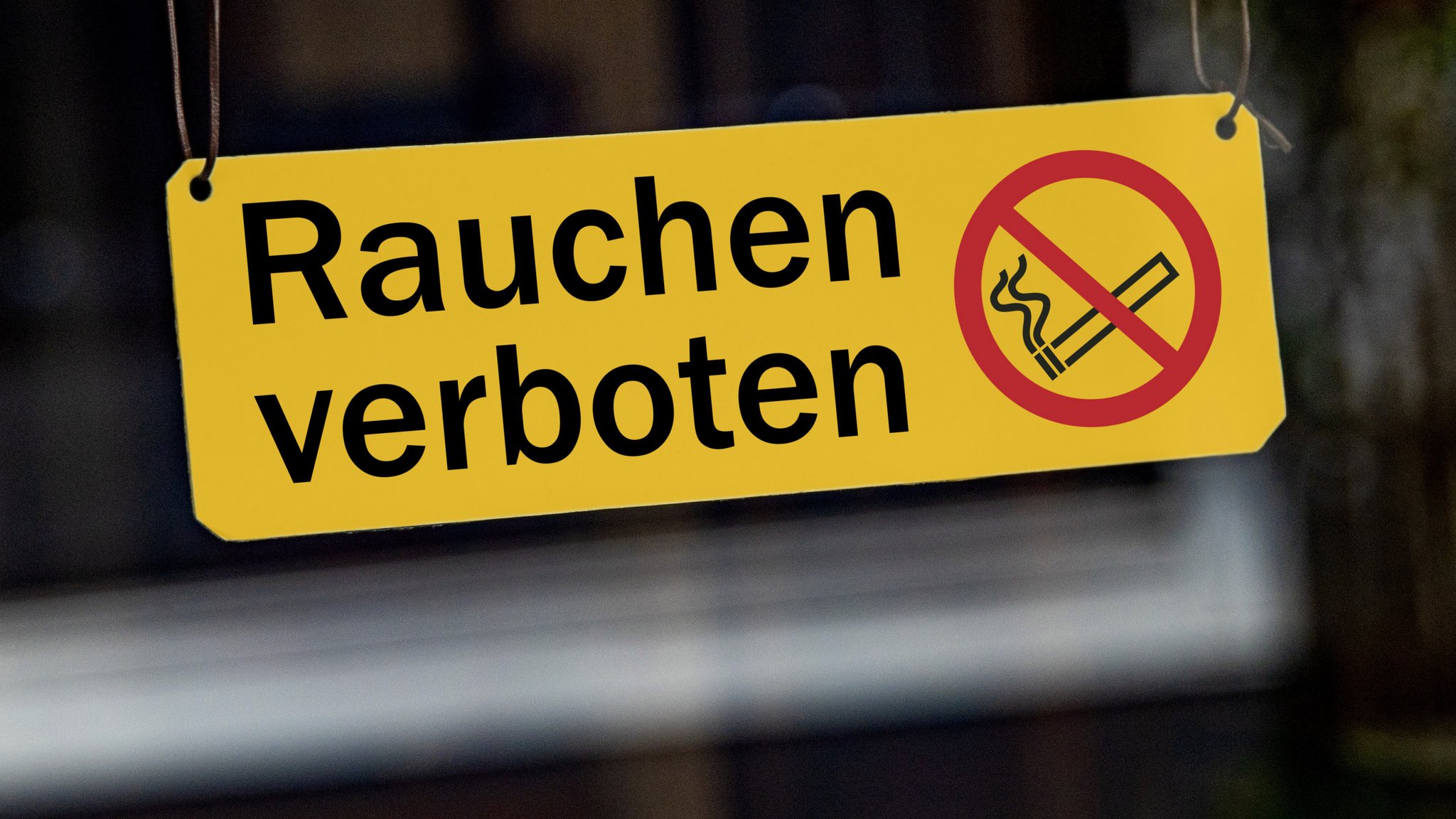 (Symbolbild) Ein Schild mit der Aufschrift "Rauchen verboten" und einem Piktogramm mit einer durchgestrichenen Zigarette hängt in einem Schaufenster (Archiv- und Symbolbild) | Bild: picture alliance / SULUPRESS.DE | Torsten Sukrow / SULUPRESS.DE (Symbolbild) Ein Schild mit der Aufschrift "Rauchen verboten" und einem Piktogramm mit einer durchgestrichenen Zigarette hängt in einem Schaufenster (Archiv- und Symbolbild)