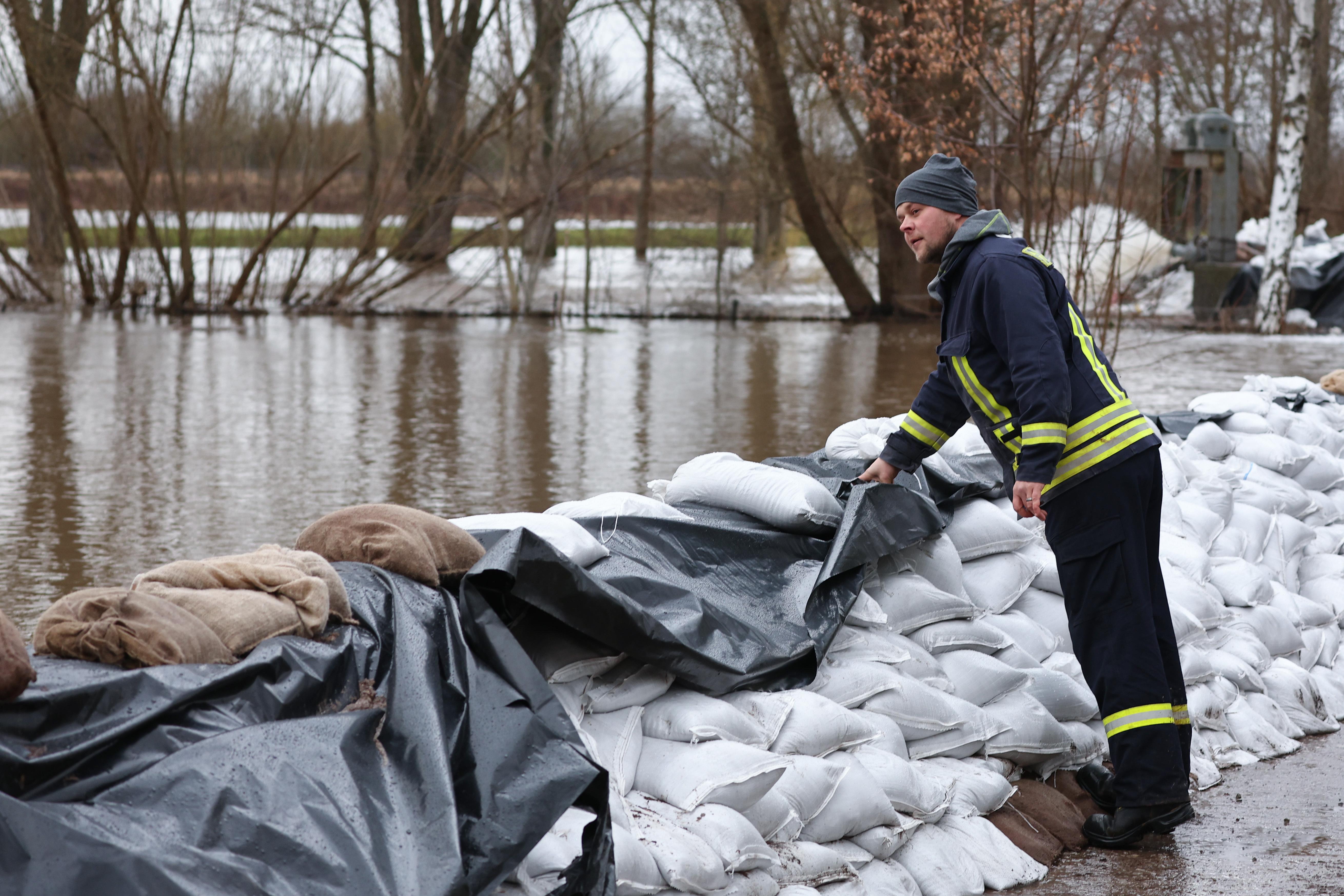 Ein Feuerwehrmann kontrolliert in Oberröblingen einen Deich aus Sandsäcken. 
