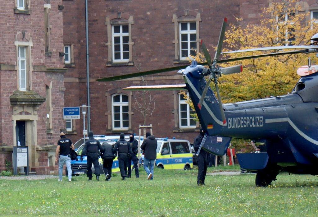 20.10.2024, Baden-Württemberg, Karlsruhe: Polizisten bringen den in Bernau bei Berlin festgenommenen mutmaßlichen IS-Unterstützer, der einen Anschlag mit Schusswaffen auf die israelische Botschaft in Berlin geplant haben soll, zur  Haftvorführung. Foto: René Priebe/dpa +++ dpa-Bildfunk +++