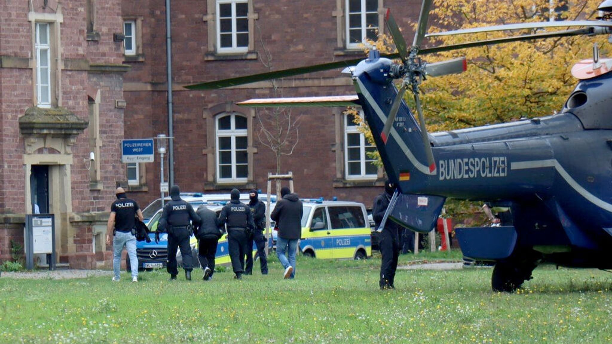 20.10.2024, Baden-Württemberg, Karlsruhe: Polizisten bringen den in Bernau bei Berlin festgenommenen mutmaßlichen IS-Unterstützer, der einen Anschlag mit Schusswaffen auf die israelische Botschaft in Berlin geplant haben soll, zur  Haftvorführung. Foto: René Priebe/dpa +++ dpa-Bildfunk +++