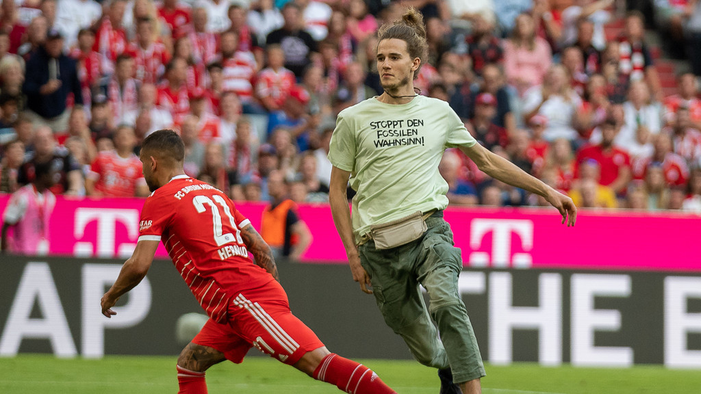 Lucas Hernandez (FC Bayern München, #21), stellt einem Flitzer ein Bein.