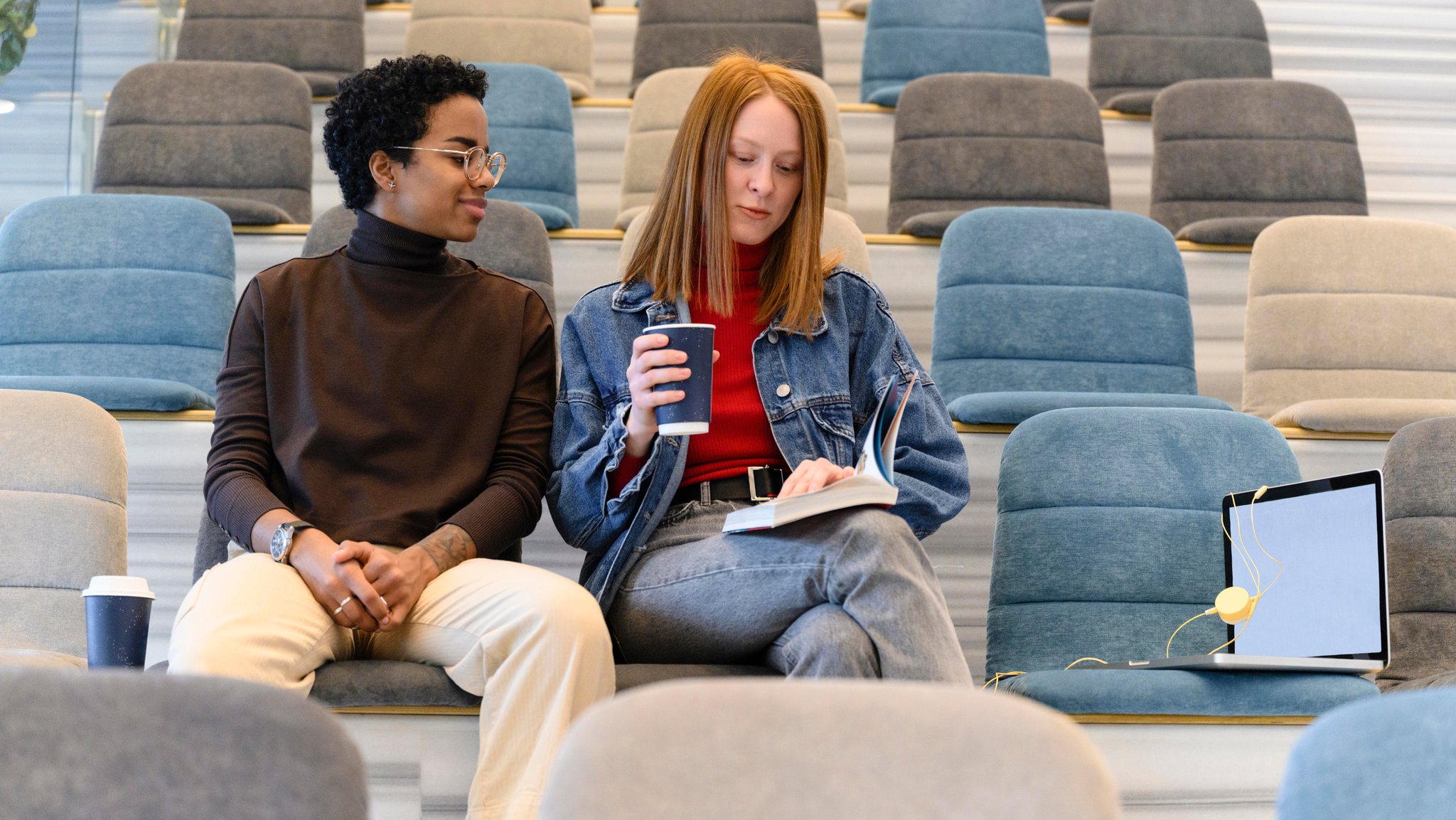 (Symbolbild) Zwei Studierende sitzen in einem modernen Hörsaal.