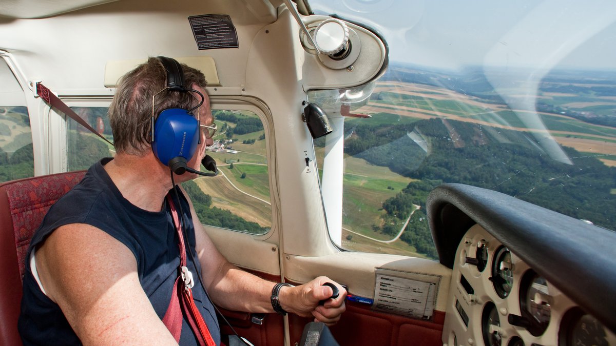 Ein Pilot in einem Flugzeug bei einem Beobachtungsflug wegen Waldbrandgefahr