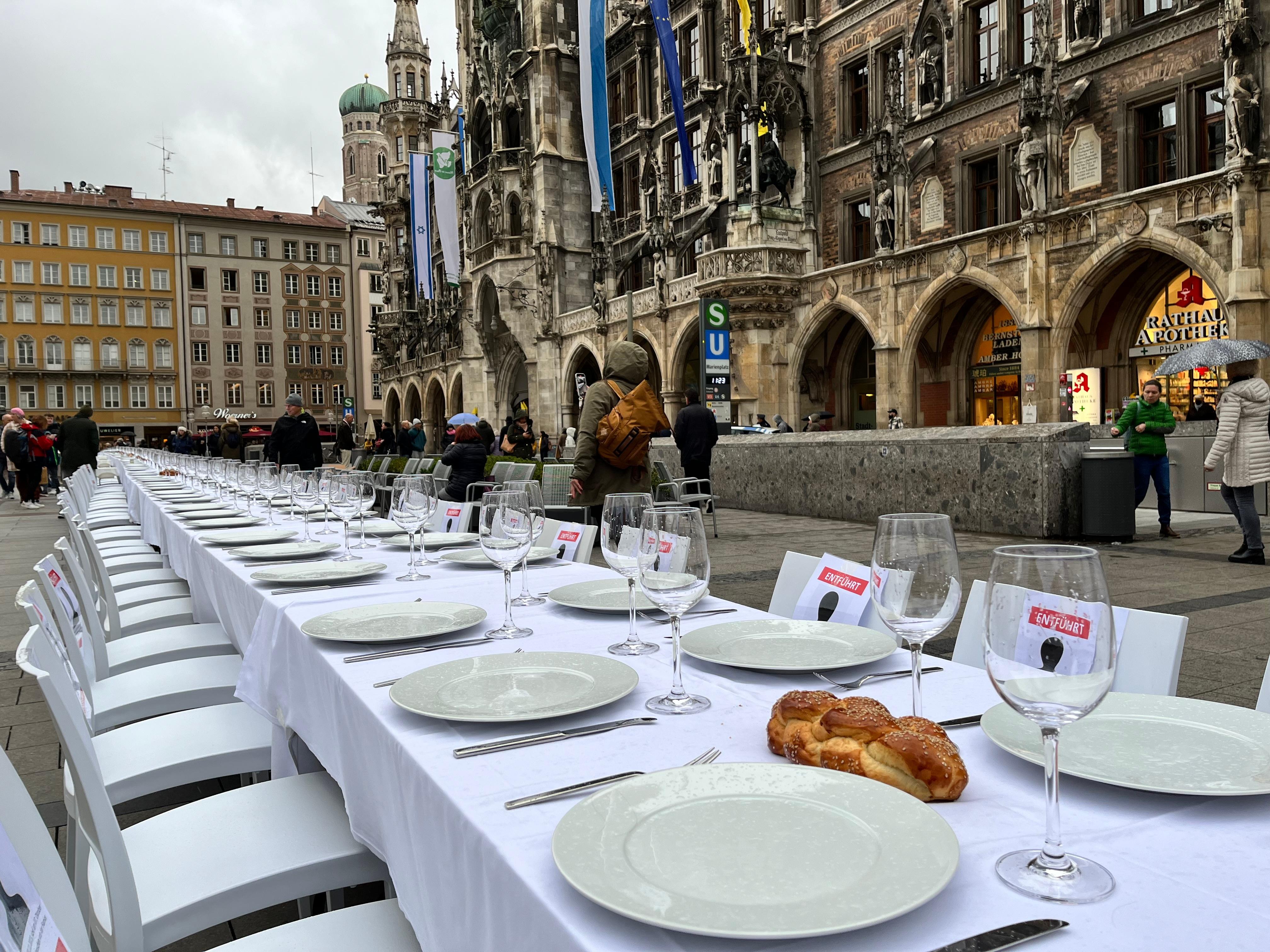 Zu sehen ist die weiße Schabbattafel mit Geschirr und Broten bedeckt am Marienplatz in München
