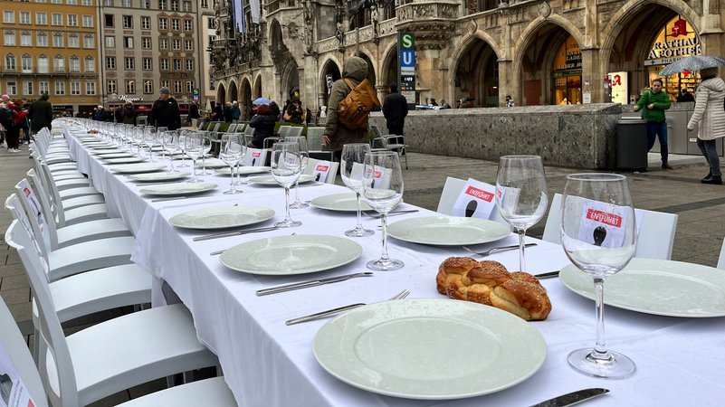 Zu sehen ist die weiße Schabbattafel mit Geschirr und Broten bedeckt am Marienplatz in München