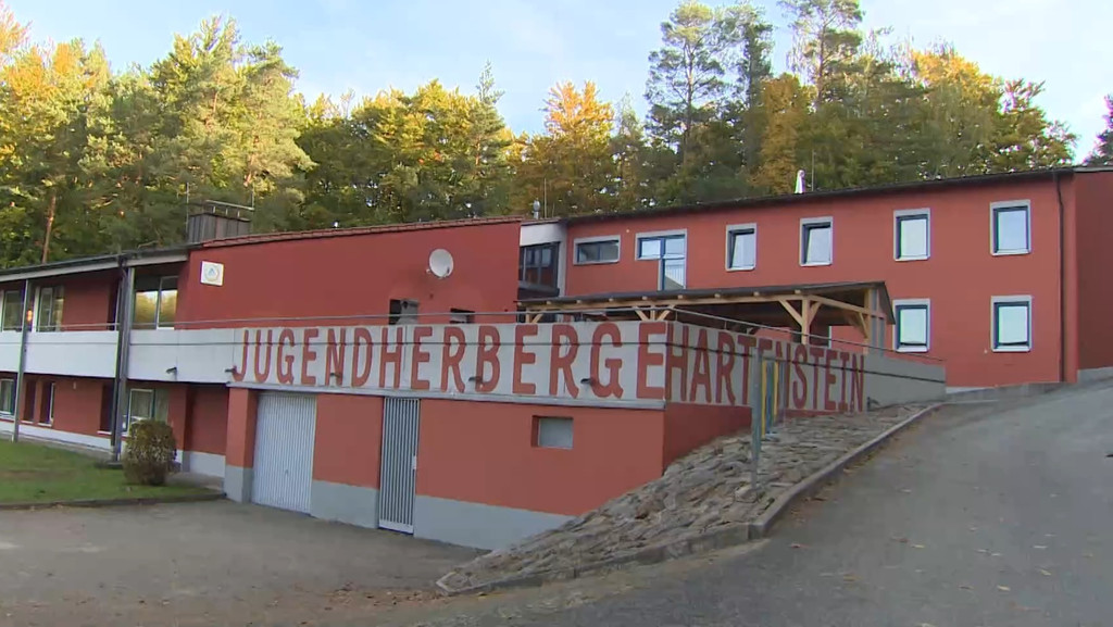 Ein flaches, rotes Gebäude mit der Aufschrift "Jugendherberge Hartenstein"