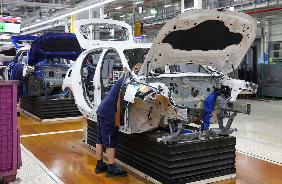 Mitarbeiter arbeiten an einem BMW 1er im BMW Group Werk Leipzig