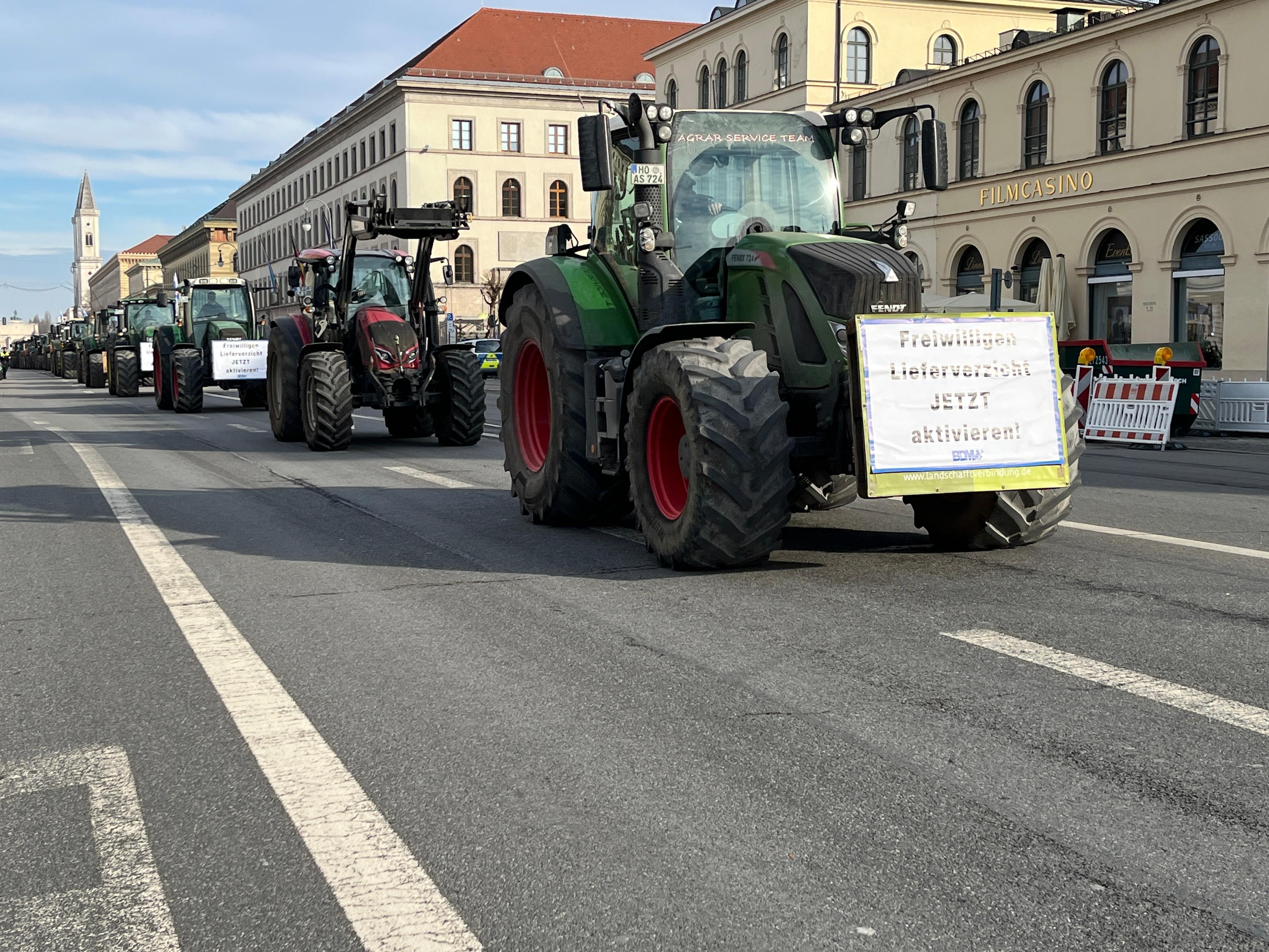 Landwirte fahren im Konvoi mit ihren Schleppern und angebrachten Transparenten am Odeonsplatz in Richtung Innenstadt.