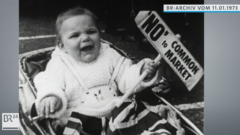 Kleinkind im Kinderwagen, das ein Schild mit der Aufschrift "No" to Common Market in der rechten Hand hält