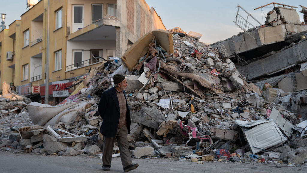 23.02.2023, Türkei, Iskenderun: Ein Mann geht durch die Trümmer von Gebäuden, die durch das Erdbeben eingestürzt sind. Zweieinhalb Wochen nach der Erdbeben-Katastrophe im türkisch-syrischen Grenzgebiet ist die Zahl der Toten auf mehr als 50 000 gestiegen. Foto: David Zorrakino/EUROPA PRESS/dpa +++ dpa-Bildfunk +++