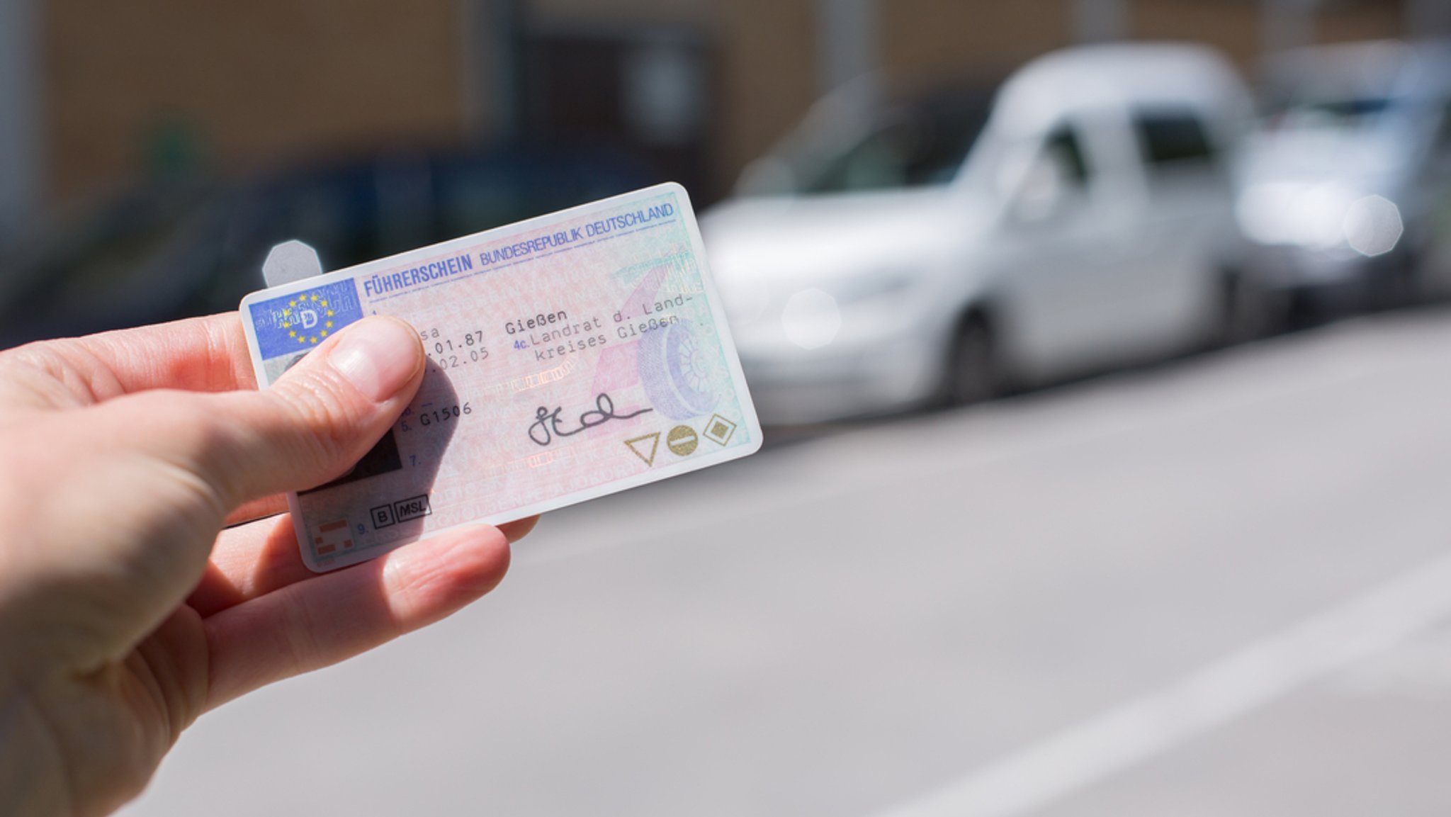 Eine Person hält einen Führerschein in der Hand.