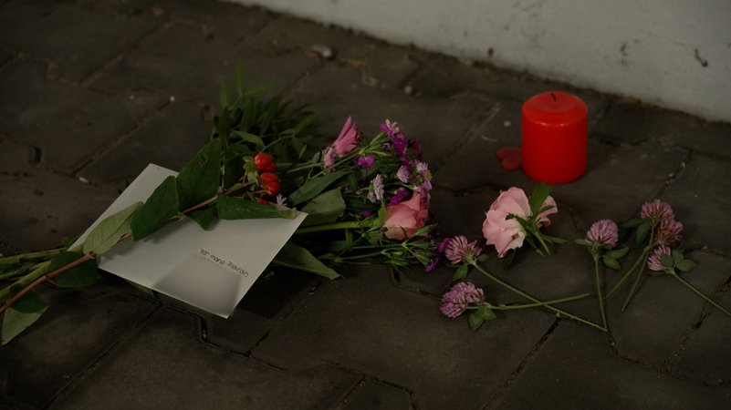 Niedergelegte Blumen und eine Kerze für die 19-jährige Tote.