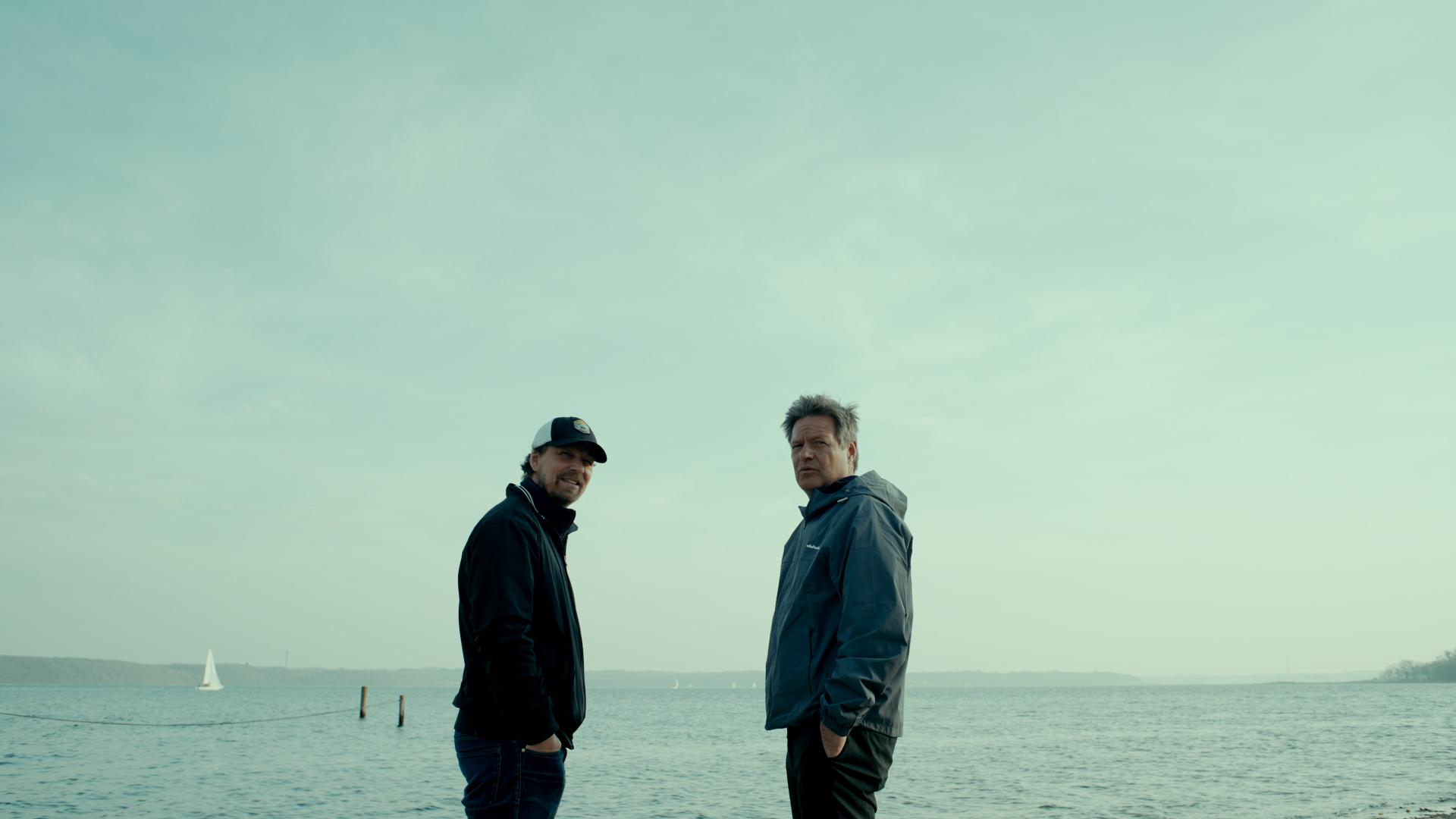 Filmemacher Lars Jessen (li.) im Gespräch mit Robert Habeck, am Strand