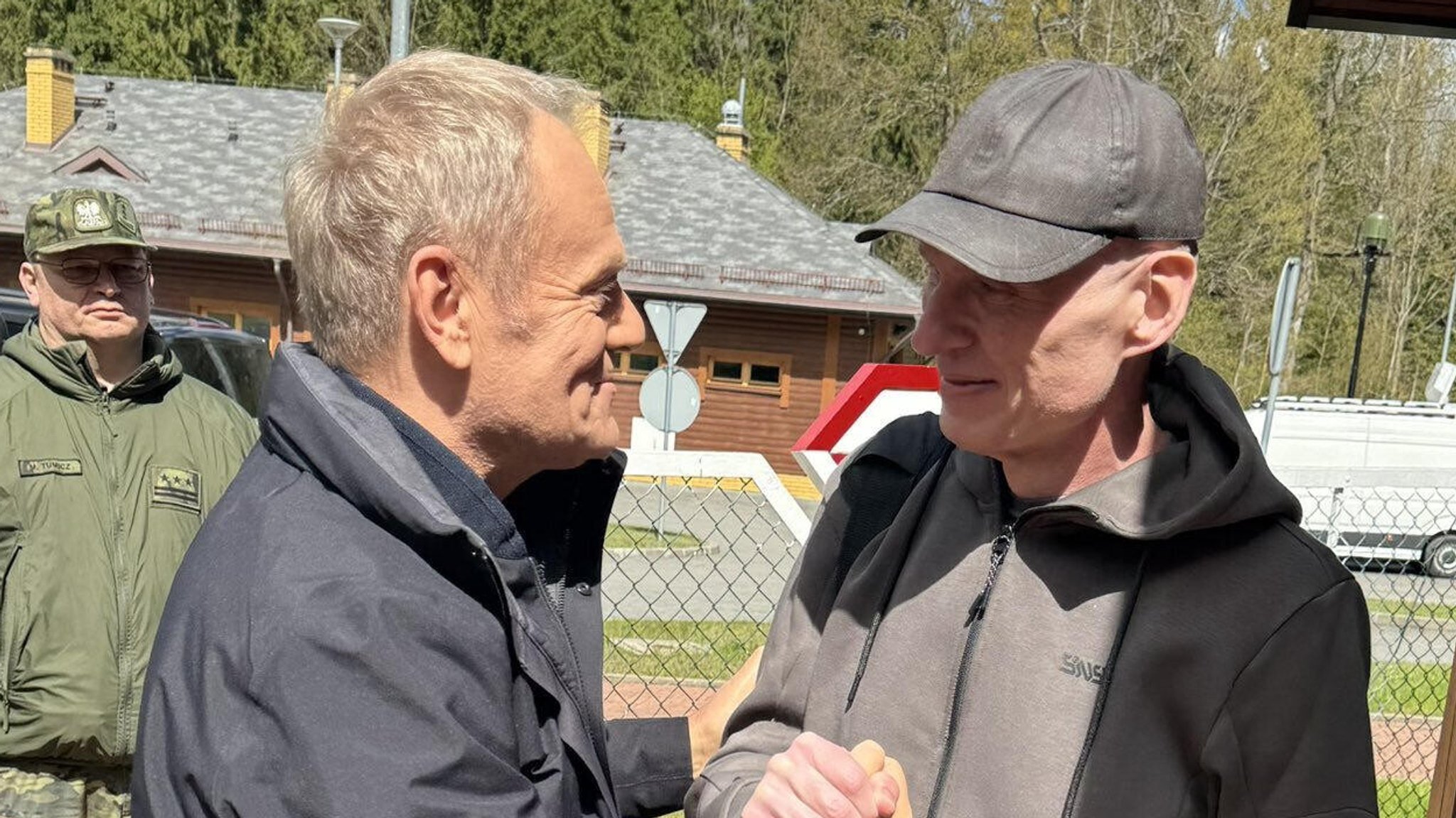 Der polnische Premierminister Donald Tusk begrüßt den Journalisten Andrzej Poczobut nach dessen Freilassung an der polnisch-weißrussischen Grenze.