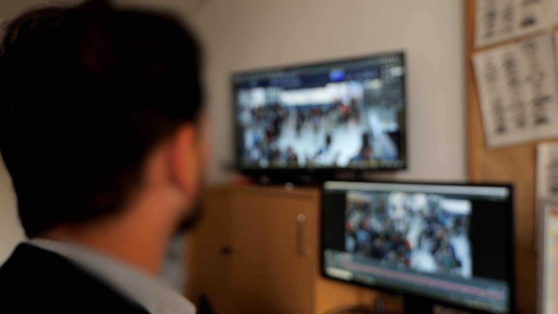 Hauptkommissar Mark B. vor Monitoren mit Bildern aus Überwachungskameras des Münchner Hauptbahnhofs