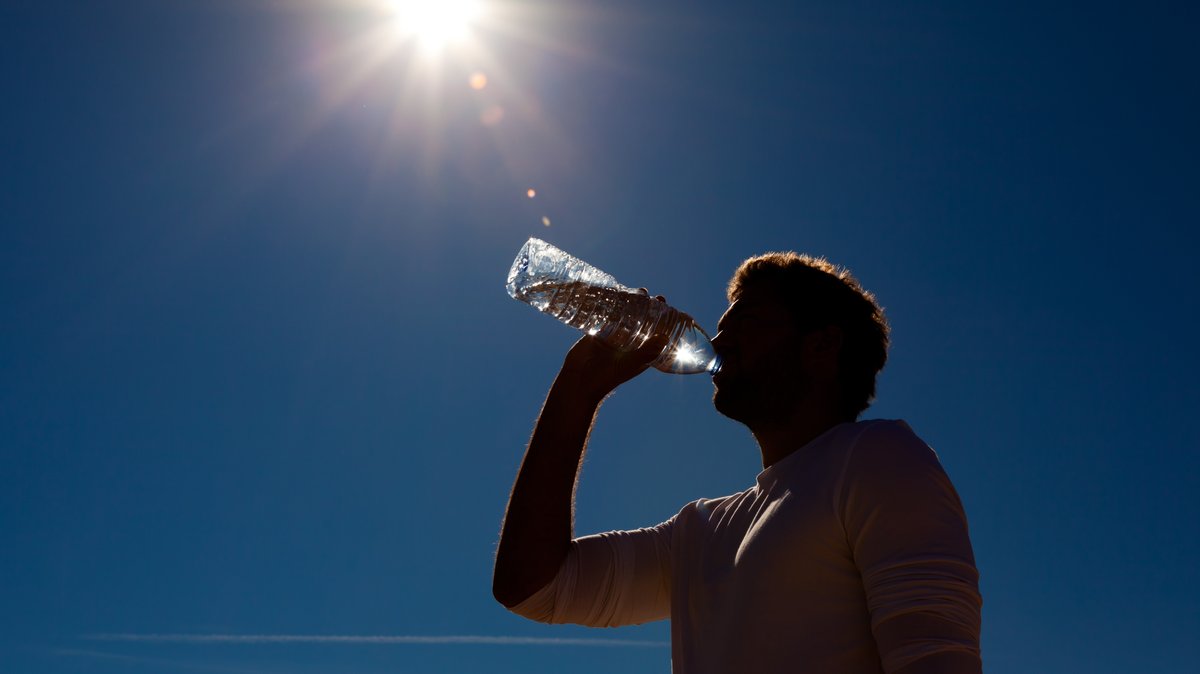Ein Mann trinkt aus einer Wasserflasche (Symbolbild)