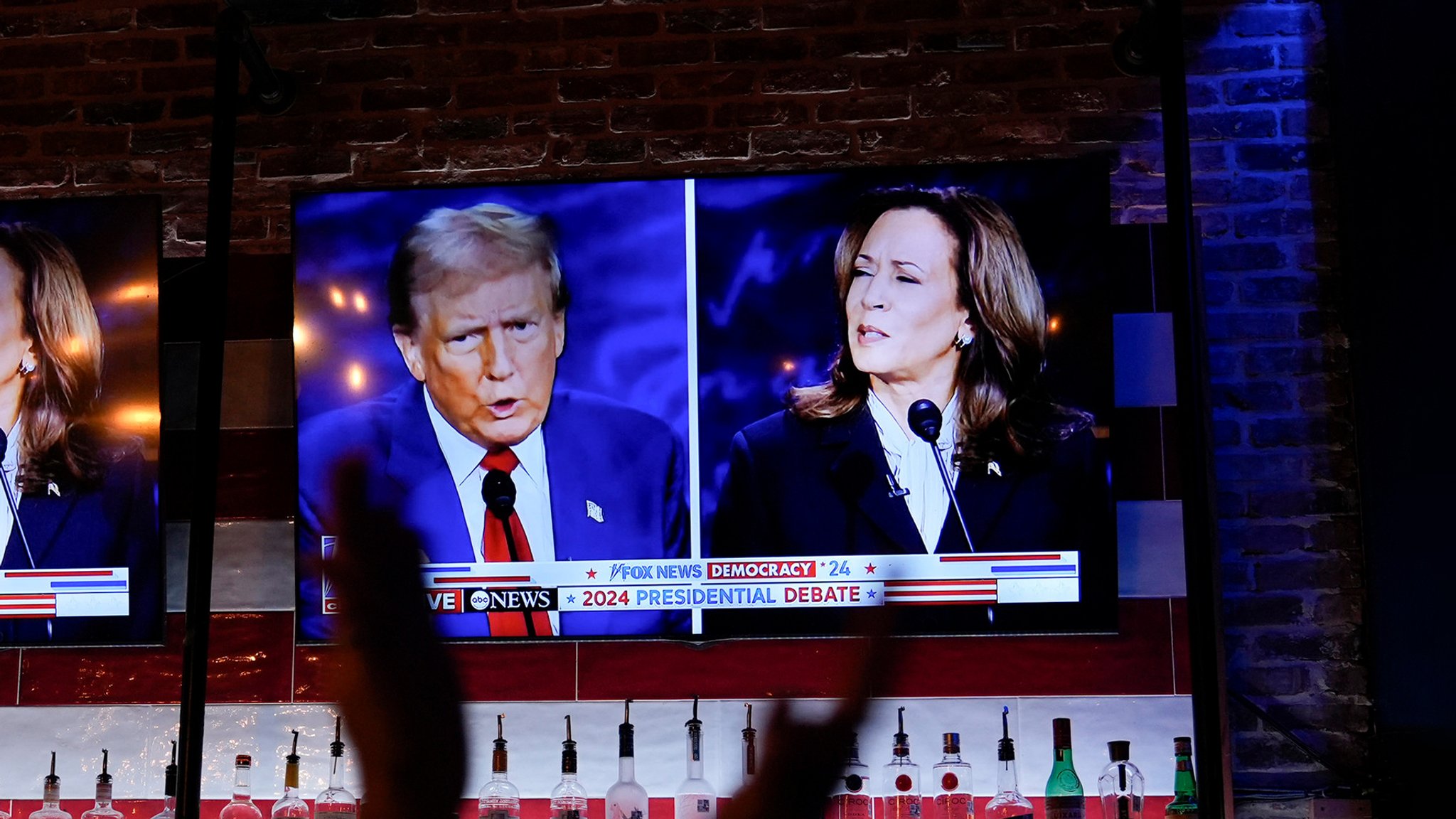 Die Kontrahenten Donald Trump und Kamala Harris auf einem Bildschirm.