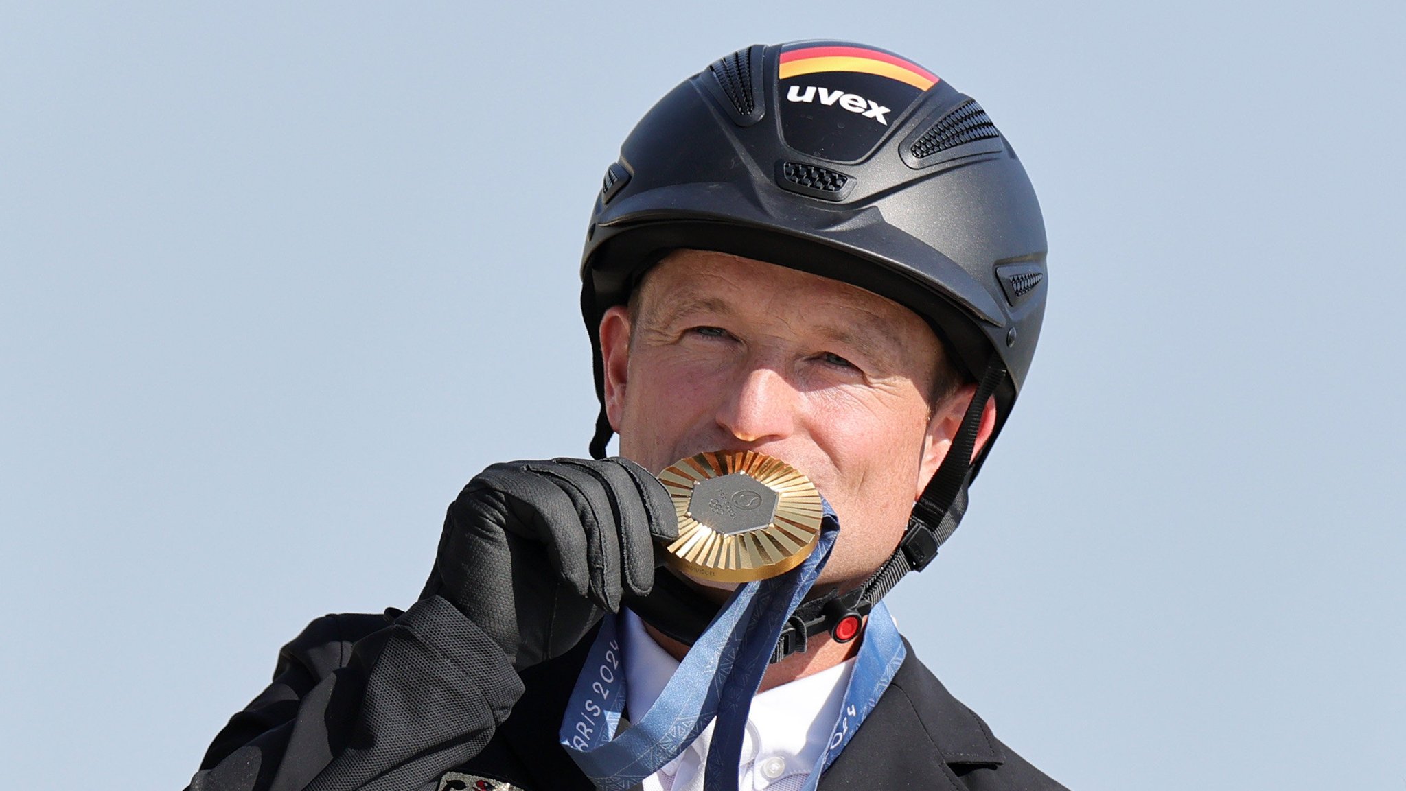 29.07.2024, Frankreich, Versailles: Olympia, Paris 2024, Pferdesport, Vielseitigkeit, Einzel, Springreiten, Deutschlands Michael Jung jubelt bei der Siegerehrung über Gold. Foto: Rolf Vennenbernd/dpa +++ dpa-Bildfunk +++