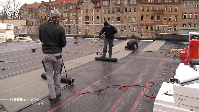 Baurarbeiter führen Arbeiten auf einem Dach durch.