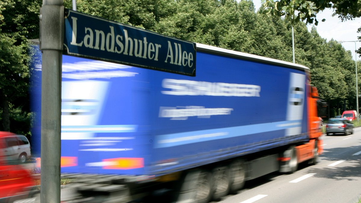 Im Vordergrund das Straßenschild Landshuter Alee. Im Hintergrund fährt ein Lastwagen.