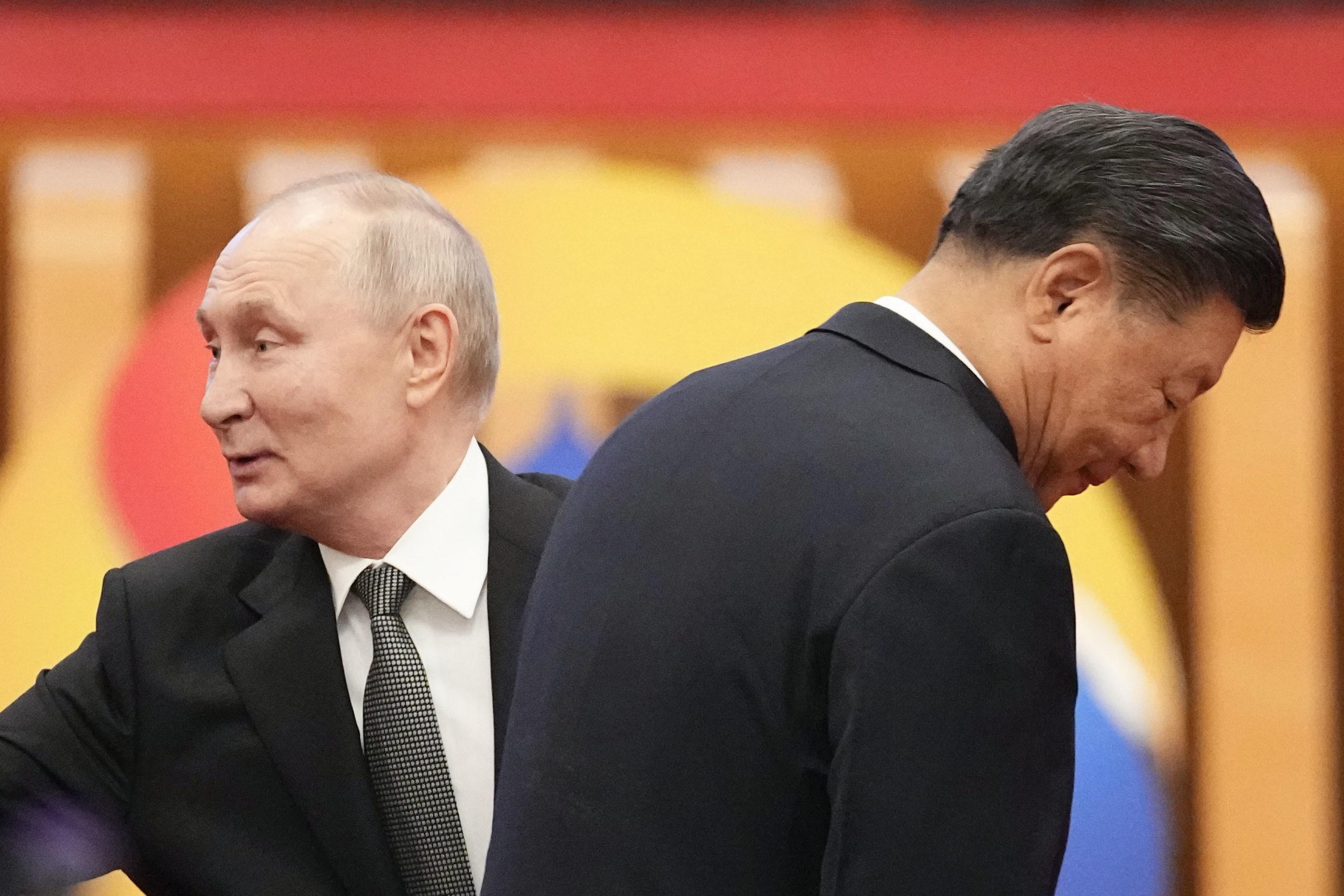 Die beiden Politiker Wladimir Putin (links) und Xi Jinping wenden sich voneinander ab und schauen in entgegengesetzte Richtungen.