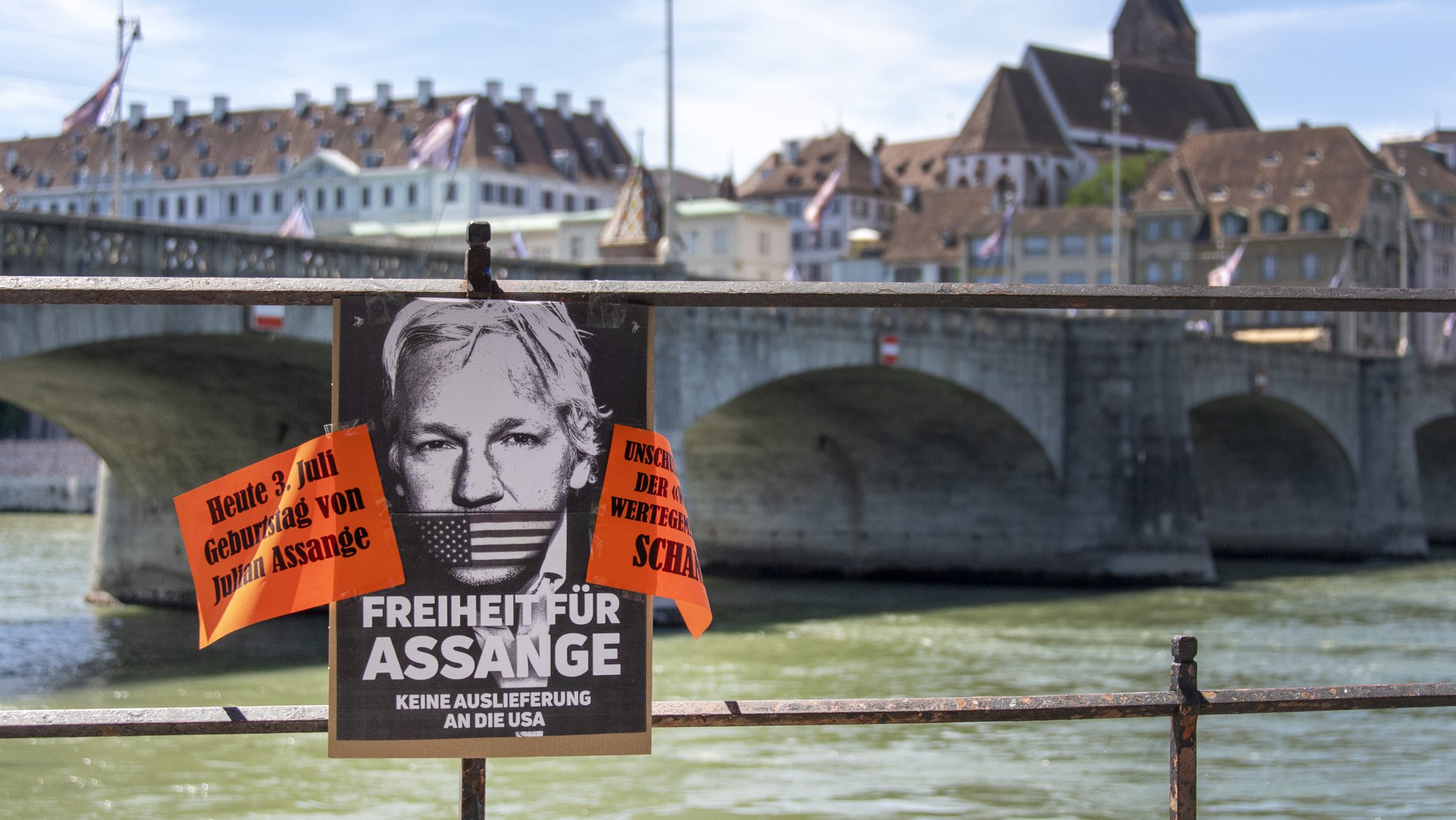 Ein Plakat fordert im Juli 2022 Freiheit fuer Julian Assange - am Rheinufer in Basel 