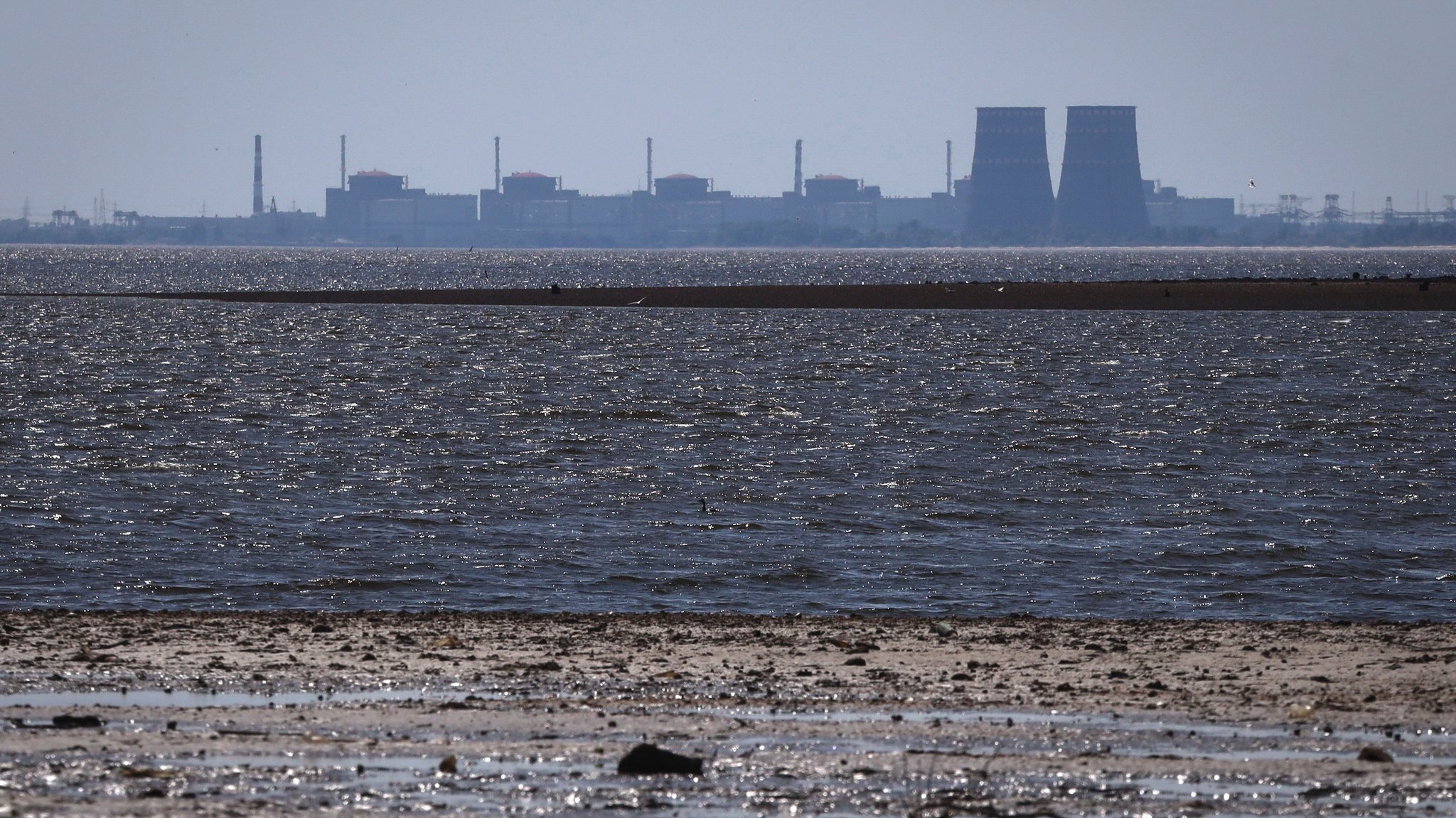 Ukraine, Energodar: Das Kernkraftwerk Saporischschja, ist im Hintergrund des flachen Kachowka-Stausees nach der Zerstörung des gleichnamigen Staudamms zu sehen. Die Anlage ist seit 2022 unter russischer Besatzung.