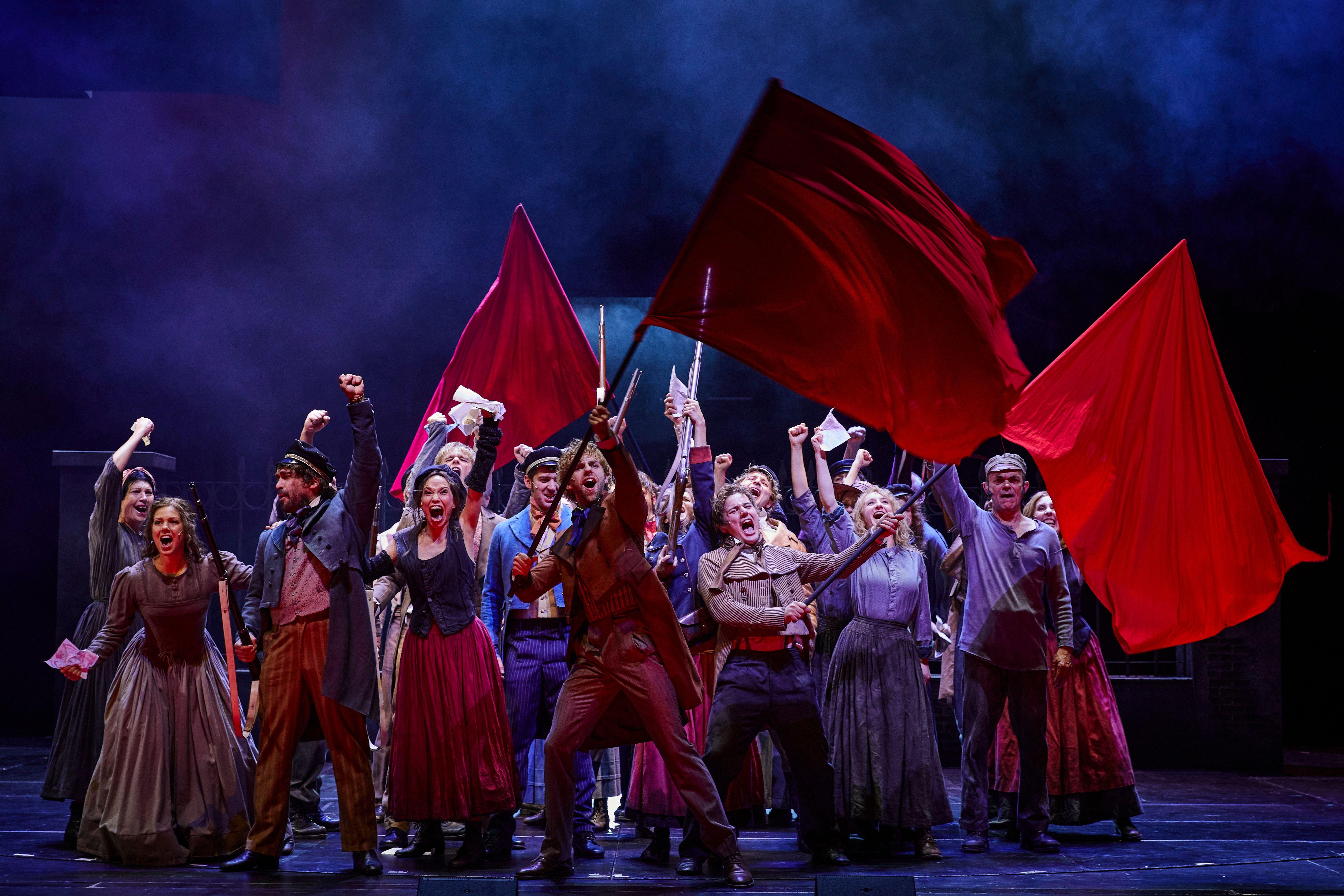 Mitwirkende schwenken rote Fahnen