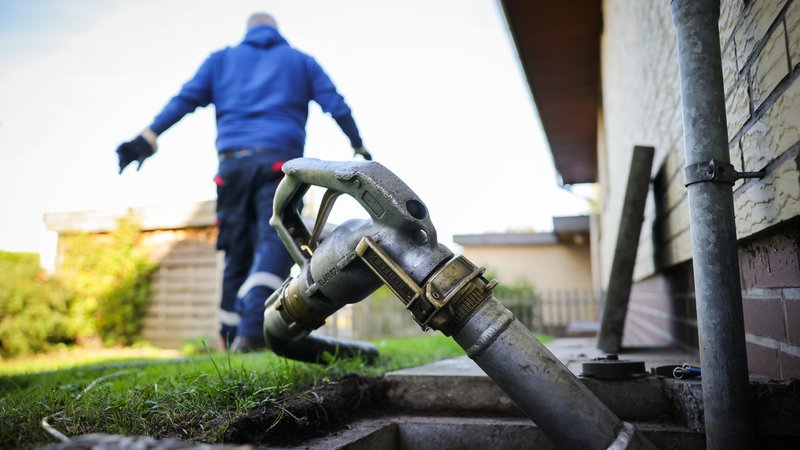 Ein Schlauch mit Zapfpistole ist an einem Füllstutzen für die Heizöllieferung an einen Kunden in einem Einfamilienhaus befestigt. | Bild: picture alliance/dpa|Christian Charisius Ein Schlauch mit Zapfpistole ist an einem Füllstutzen für die Heizöllieferung an einen Kunden in einem Einfamilienhaus befestigt.