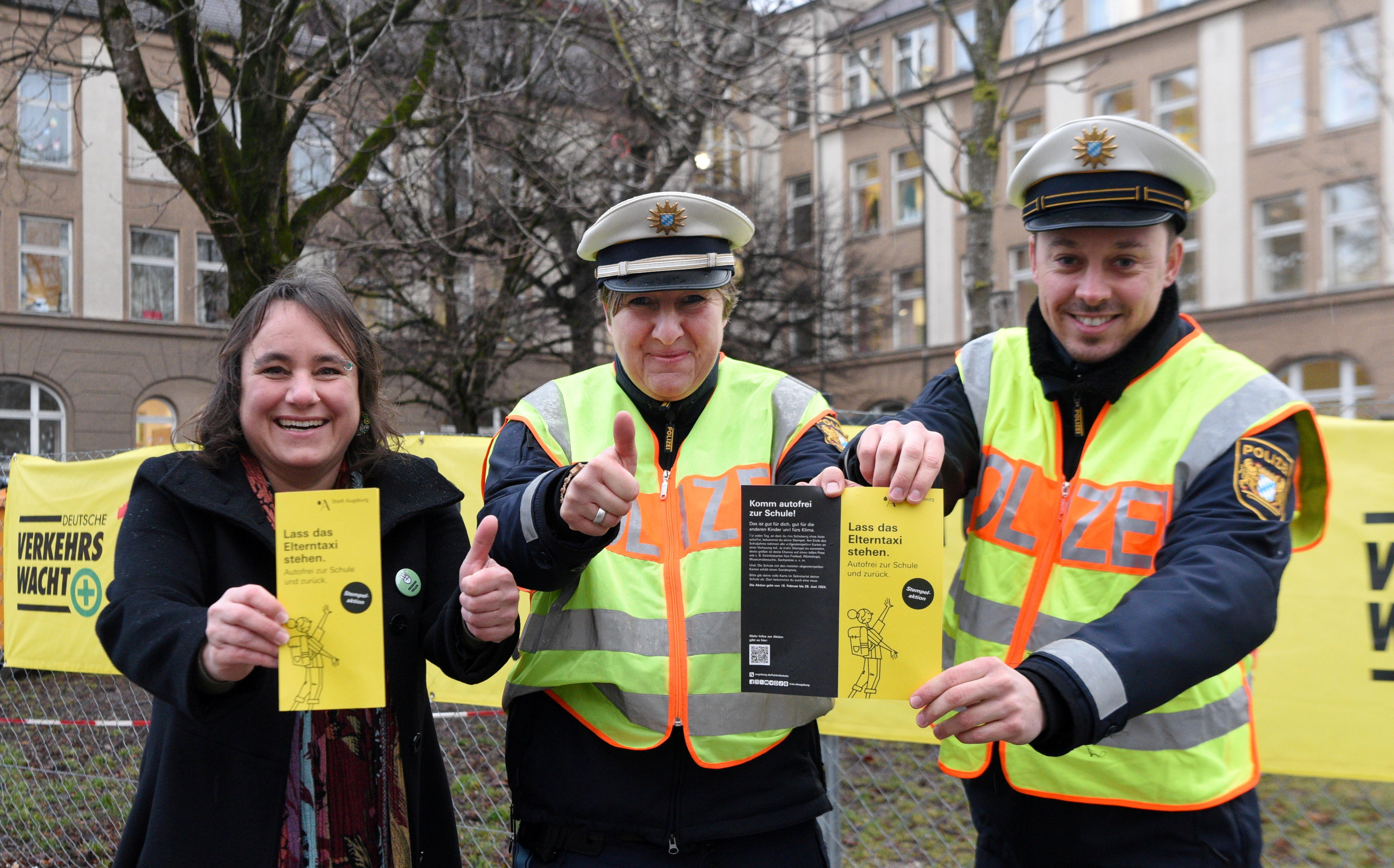 Augsburg Bürgermeisterin, Martina Wild, wirbt Angelika Czerny und Raphael Hanneder von der Polizei für die Aktion "Lass das Elterntaxi stehen". 