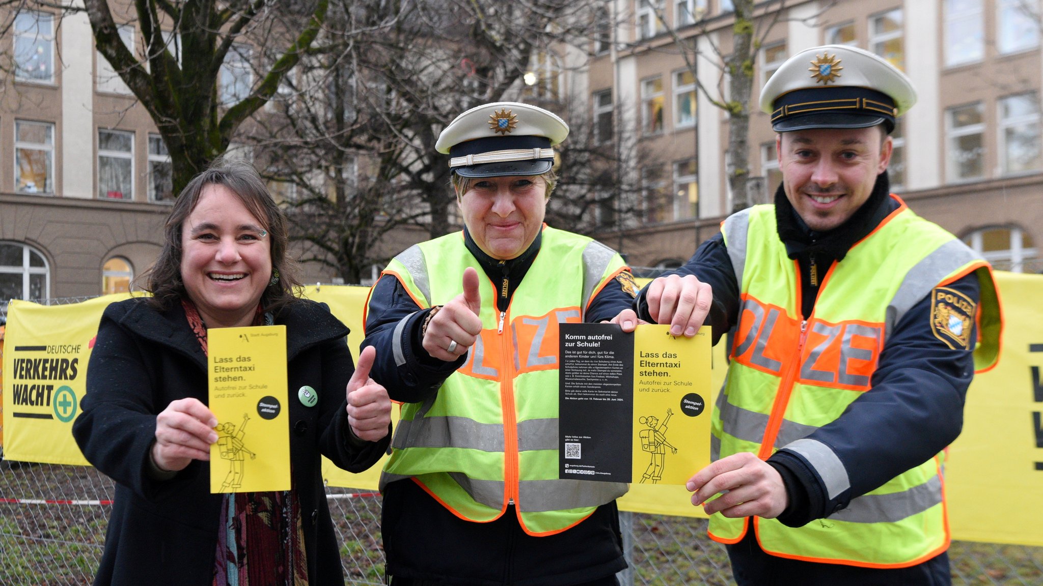 Augsburg Bürgermeisterin, Martina Wild, wirbt Angelika Czerny und Raphael Hanneder von der Polizei für die Aktion "Lass das Elterntaxi stehen". 