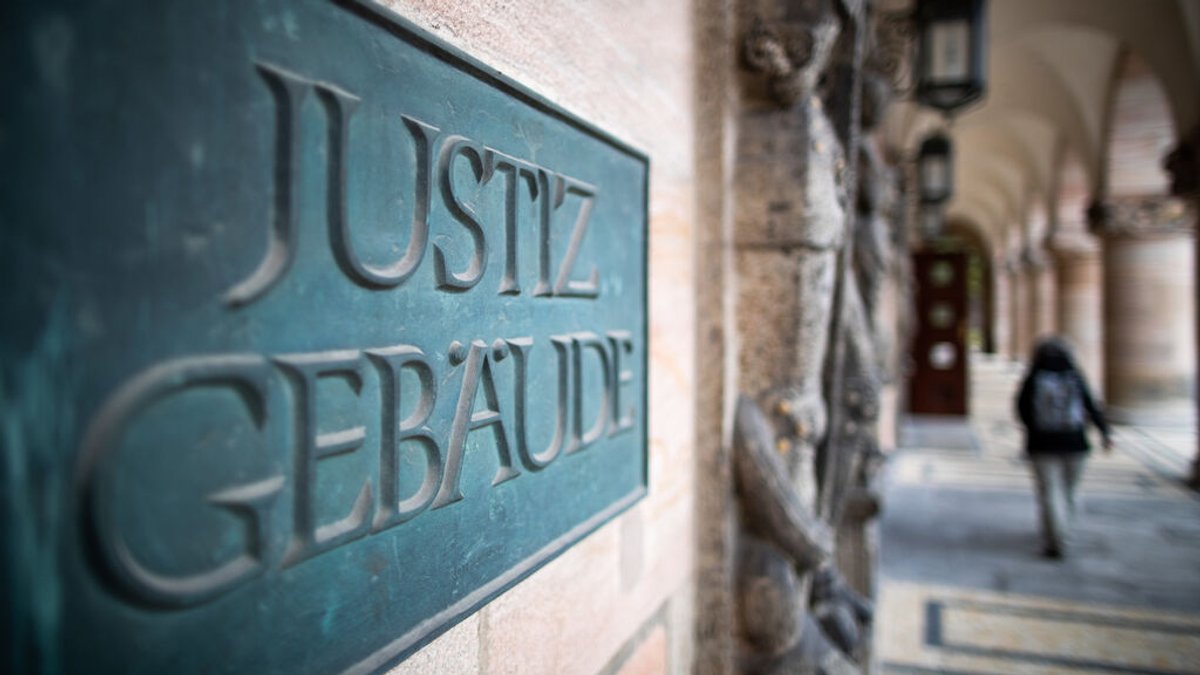 ARCHIV - 18.11.2020, Bayern, Nürnberg: Ein Schild mit der Aufschrift «Justizgebäude» hängt am Eingang vom Landgericht Nürnberg-Fürth. (zu dpa: «Betrug in Millionenhöhe - Betreiber von Pflegedienst verurteilt») Foto: Peter Kneffel/dpa +++ dpa-Bildfunk +++