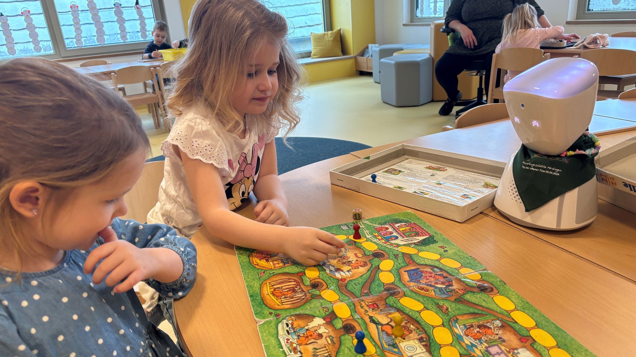 Kinder im Mörslinger Kindergarten spielen ein Brettspiel und Avatar "Elsa" spielt mit.