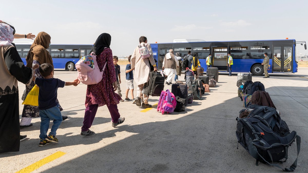 Archivbild: Schutzbedürftige Menschen gehen kurz nach dem Flug aus Kabul in Taschkent zu einem Bus (26.8.21).