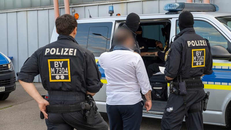 Polizeibeamte führen einen Mann zu einem Einsatzfahrzeug (Symbolbild). | Bild: picture alliance/dpa | Stefan Puchner Polizeibeamte führen einen Mann zu einem Einsatzfahrzeug (Symbolbild).