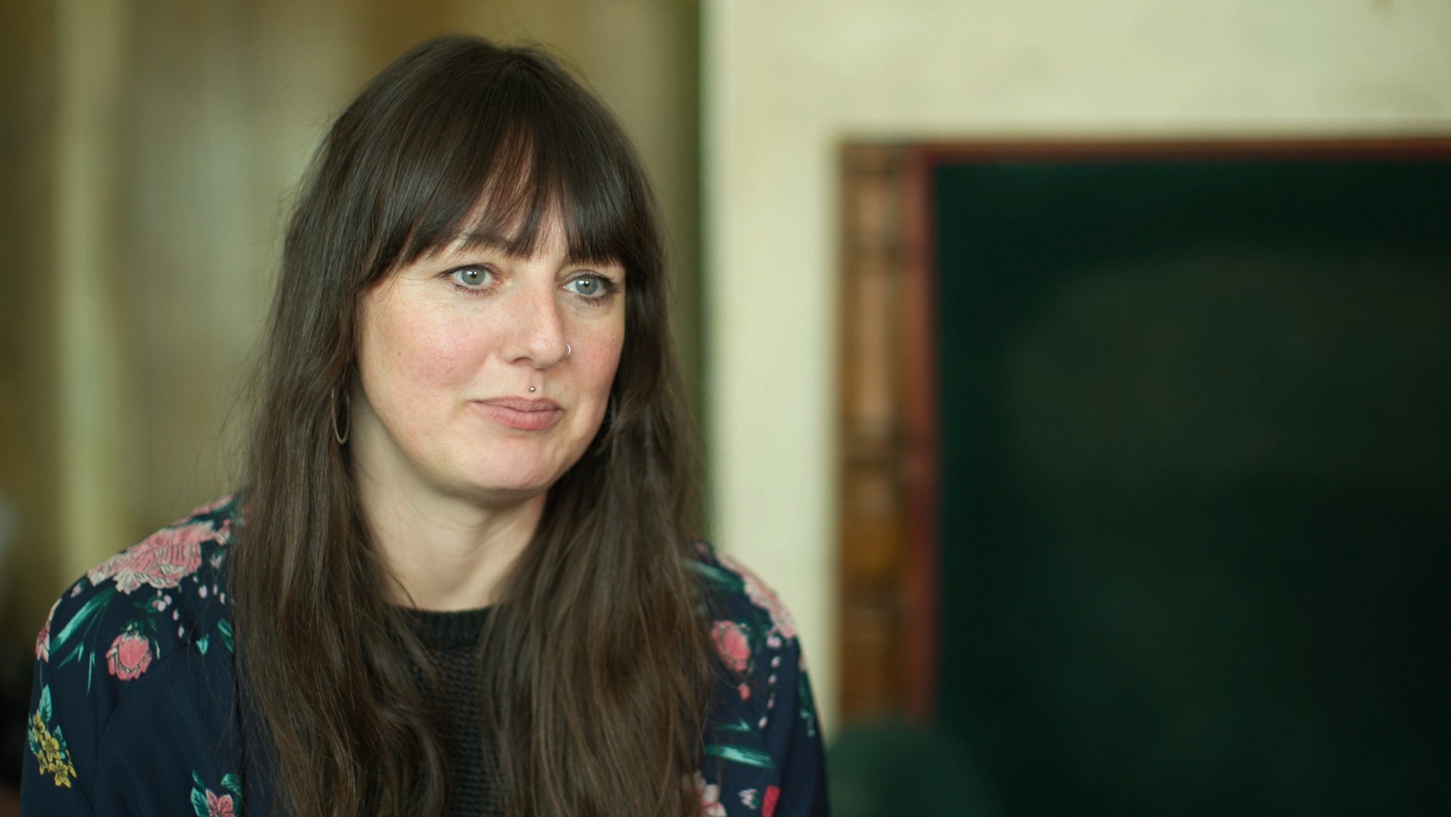 Ein Portrait einer Frau mit langen dunkelbraunen Haaren. 