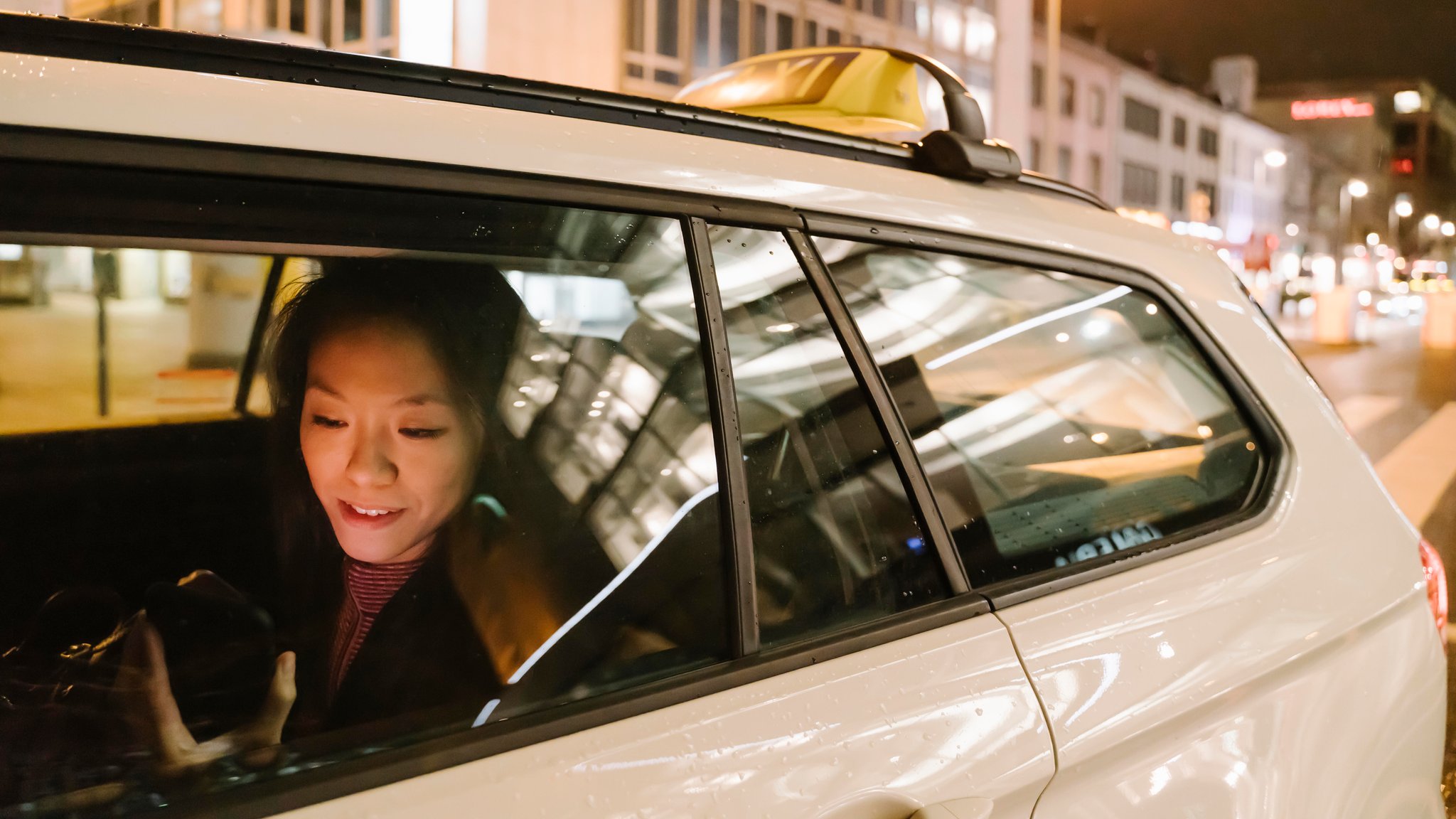Symbolbild: Eine Frau sitzt nachts in einem Taxi.