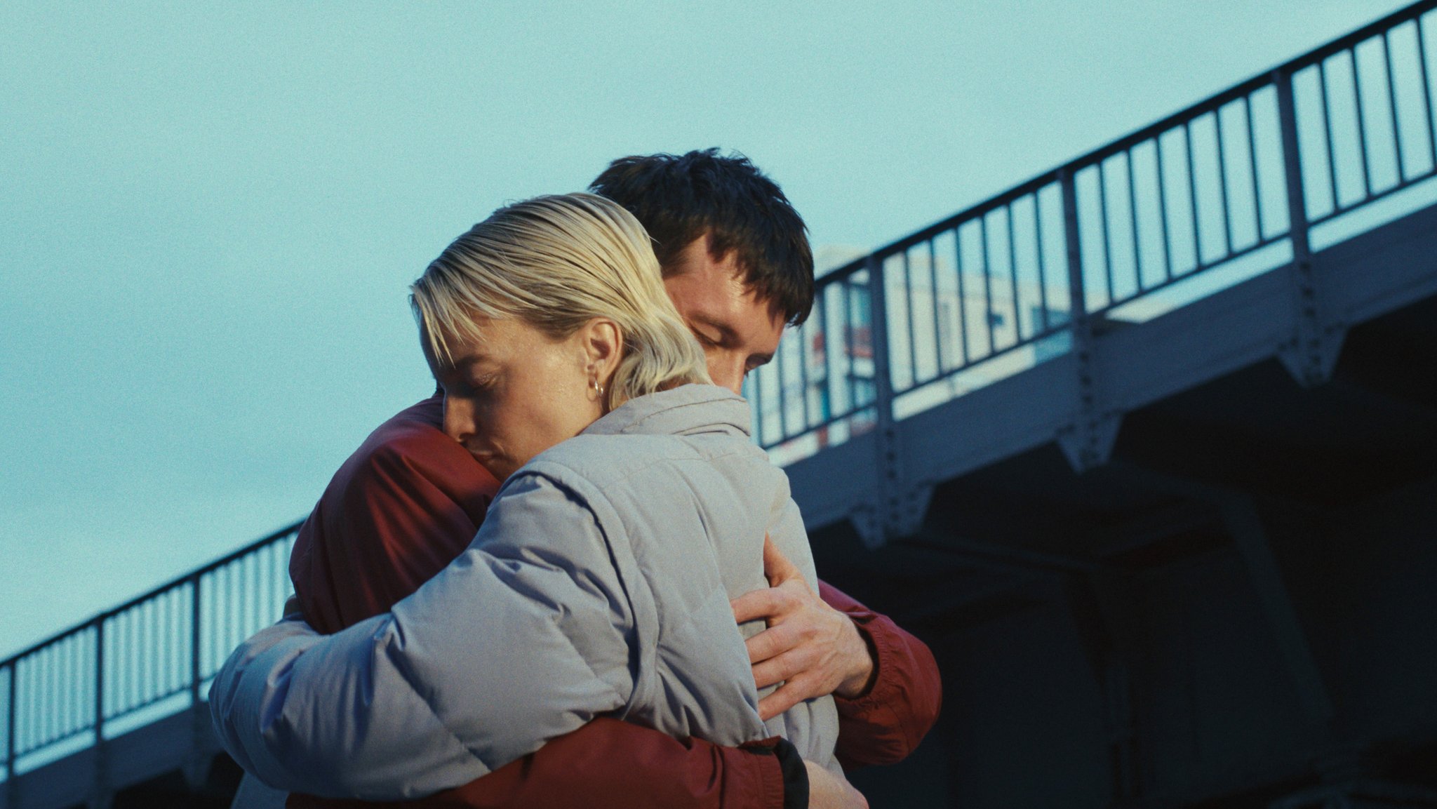 Ein Paar umarmt sich unter einer Eisenbahnbrücke in Berlin - Filmszene aus "Allegro Pastell", Regie Anna Roller