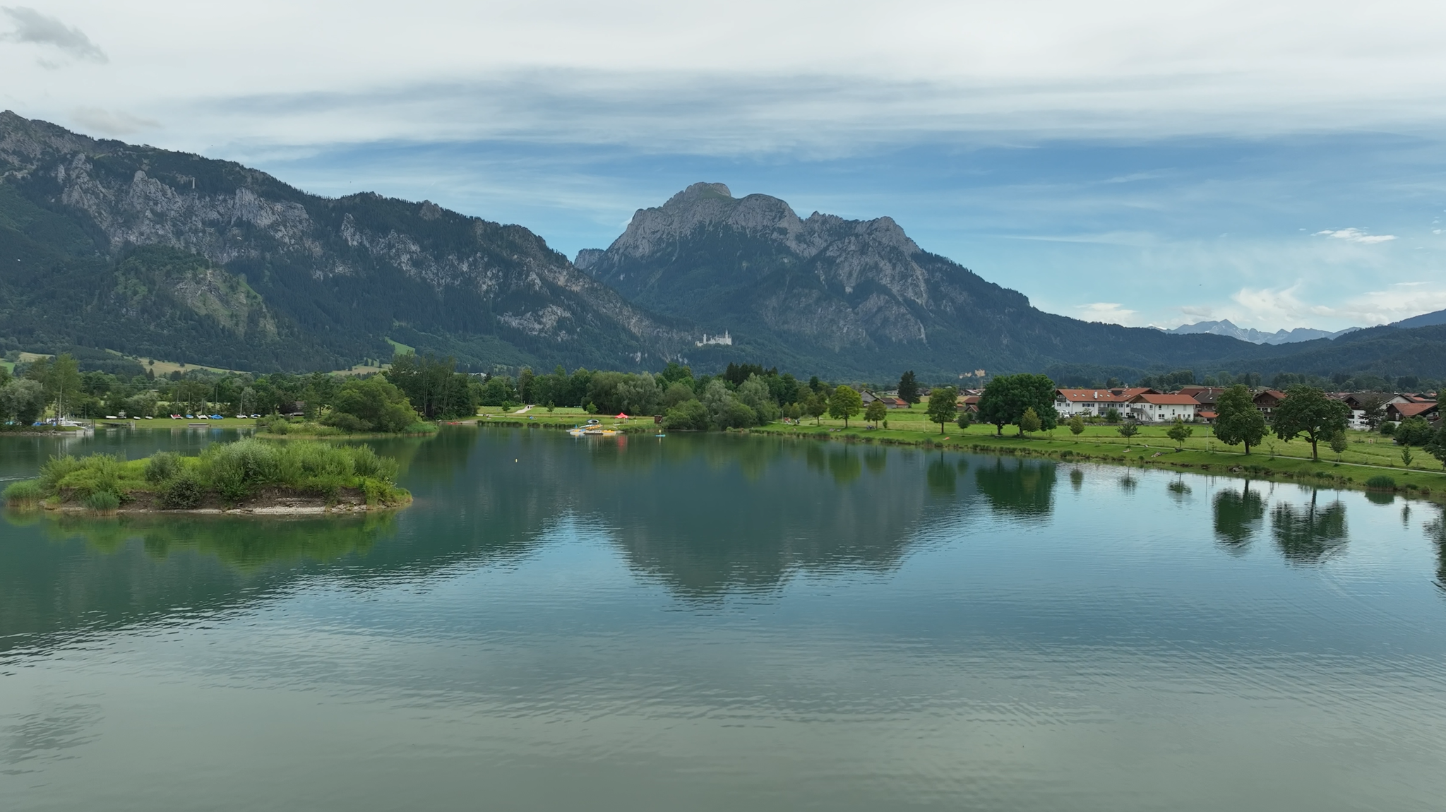 Blick auf den Forggensee im Allgäu mit Schloss Neuschwanstein im Hintergrund.