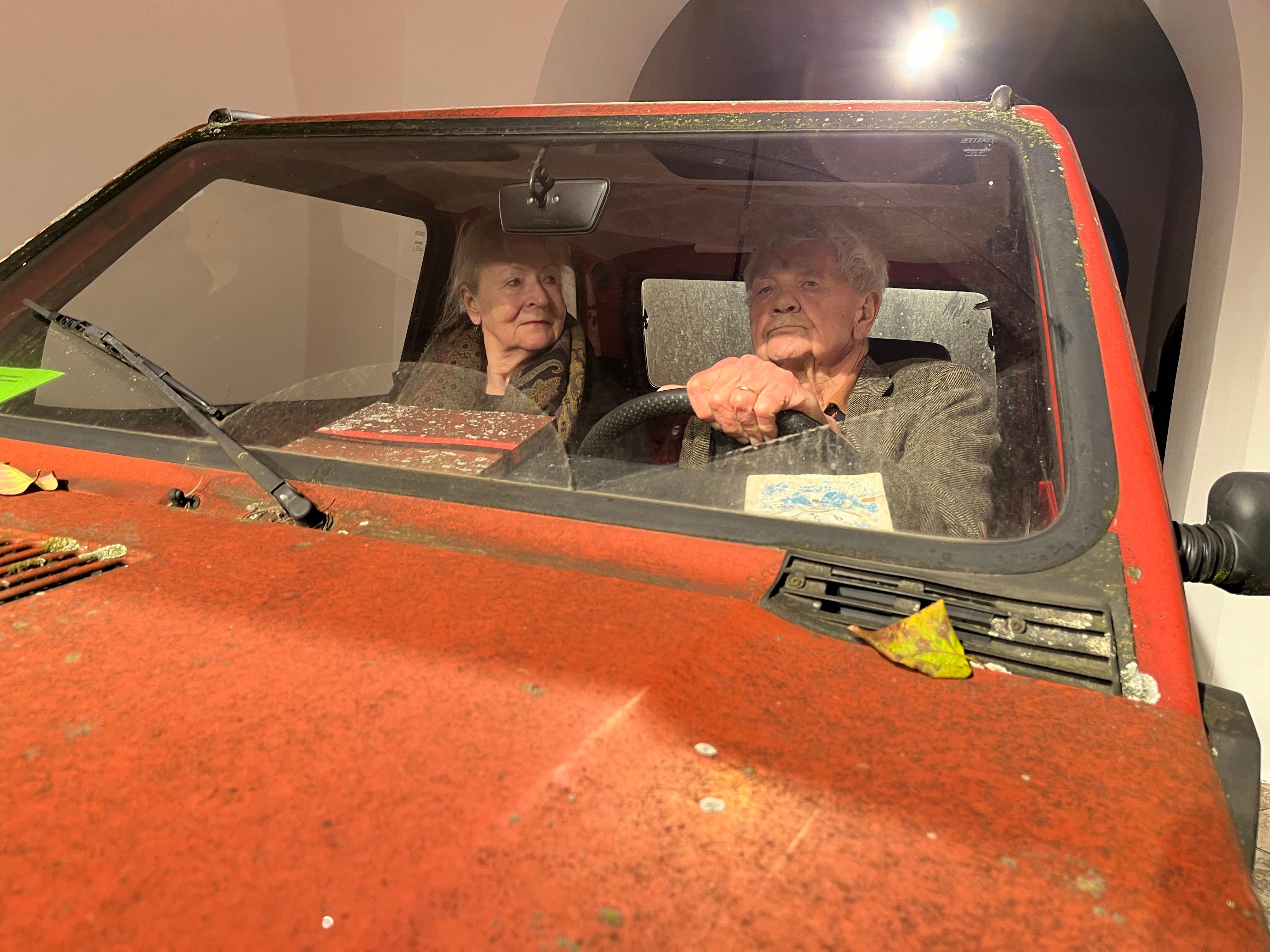 Die beiden Schriftsteller Eckhard und Regina Henscheid in ihrem alten verwitterten, aber fahrtüchtigen Fiat Panda.