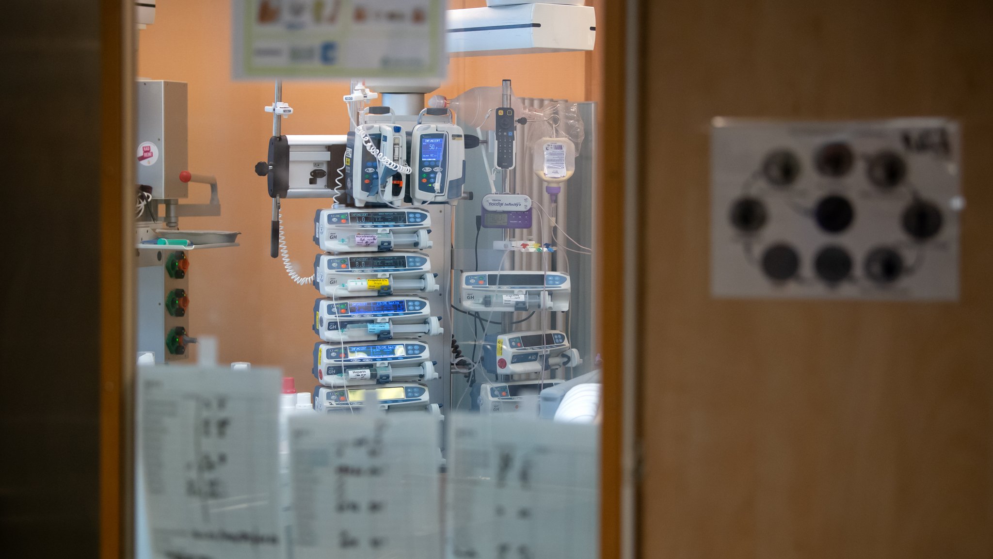 Symbolbild: Infusionspumpen sind aus einem isolierten Intensivbett-Zimmer zu sehen. Auf der Station werden Covid-19-Patienten behandelt.