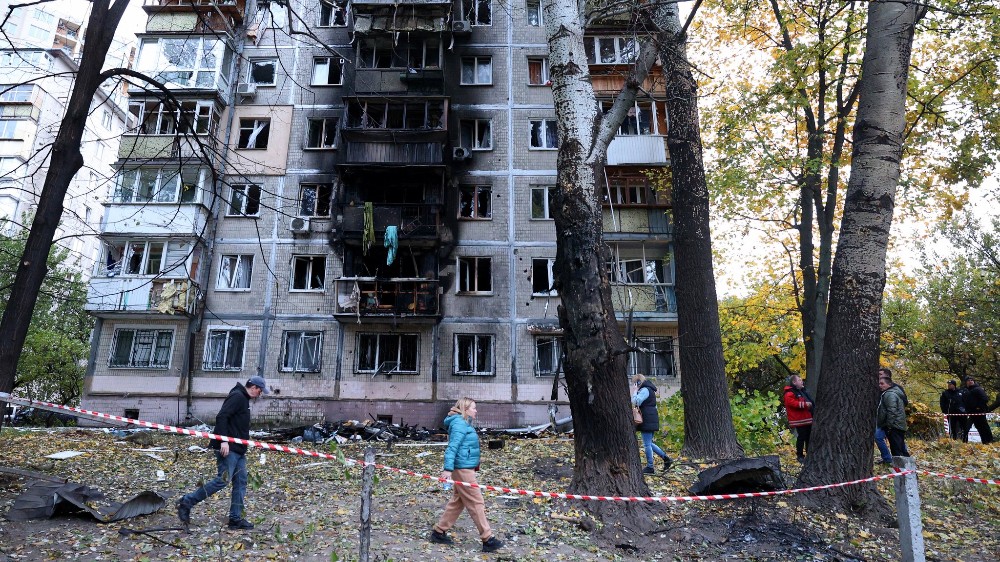 Anwohner gehen am 30. Oktober 2024 um ein Gebäude herum, das durch die Explosion eines Drohnenangriffs in Kiew beschädigt wurde.