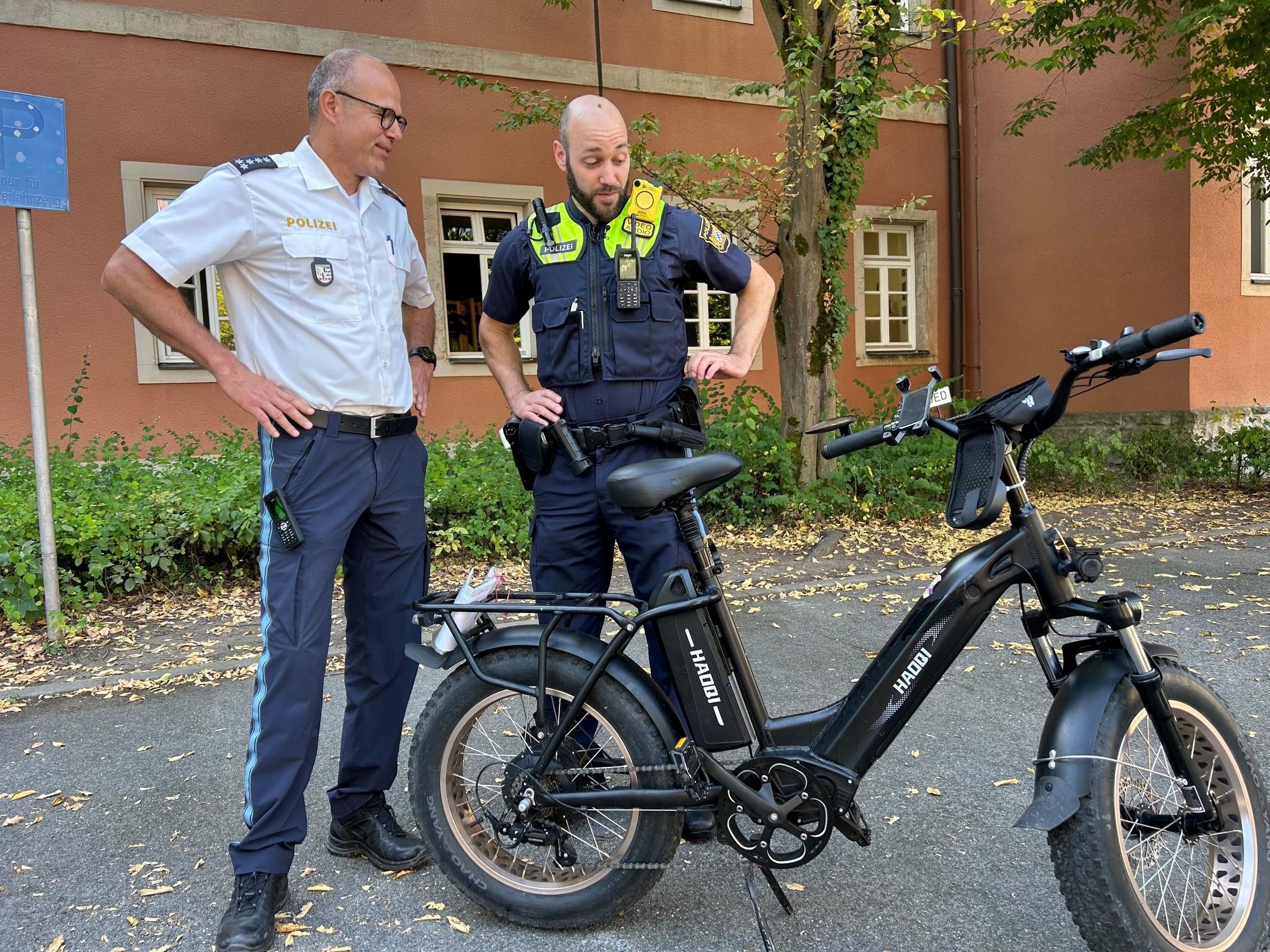 Zwei Polizisten stehen vor einem Pedelec.