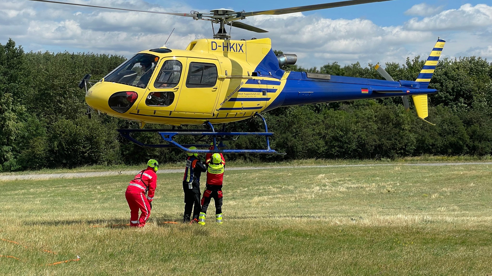 Die Teilnehmer der Flughelfer-Ausbildung müssen lernen, Behälter an einem noch fliegenden Hubschrauber zu befestigen.