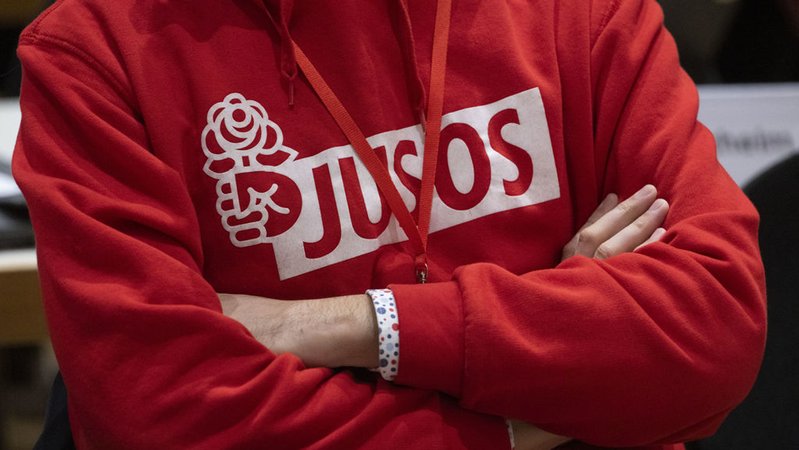 ARCHIV - 21.10.2023, Baden-Württemberg, Heilbronn: Ein Teilnehmer des Landesparteitags der SPD Baden-Württemberg hat einen Kapuzenpulli mit der Aufschrift «Jusos» an. Bei ihrem Parteitag bestimmt die SPD in Baden-Württemberg ihren Spitzenkandidaten für die Europawahl im kommenden Jahr. (zu dpa: «Jusos Schleswig-Holstein lehnen Koalitionsvertrag ab») Foto: Marijan Murat/dpa +++ dpa-Bildfunk +++ | Bild: dpa-Bildfunk/Marijan Murat ARCHIV - 21.10.2023, Baden-Württemberg, Heilbronn: Ein Teilnehmer des Landesparteitags der SPD Baden-Württemberg hat einen Kapuzenpulli mit der Aufschrift «Jusos» an. Bei ihrem Parteitag bestimmt die SPD in Baden-Württemberg ihren Spitzenkandidaten für die Europawahl im kommenden Jahr. (zu dpa: «Jusos Schleswig-Holstein lehnen Koalitionsvertrag ab») Foto: Marijan Murat/dpa +++ dpa-Bildfunk +++