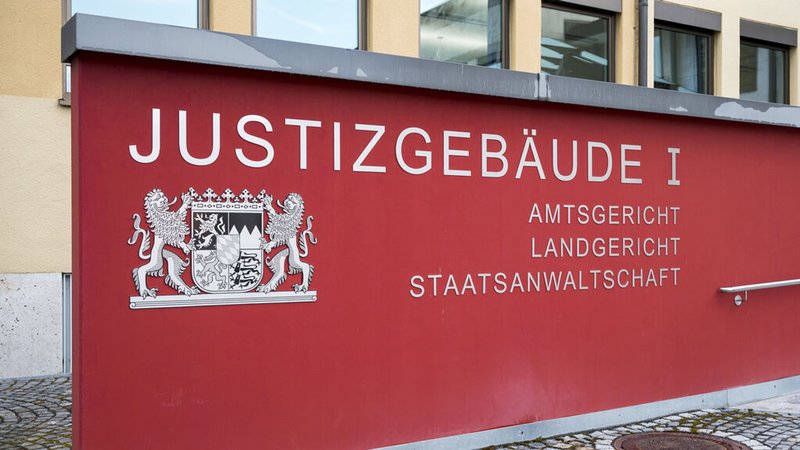 Eine rote Wand mit der Aufschrift "Justizgebäude, Amtsgericht, Landgericht, Staatsanwaltschaft".